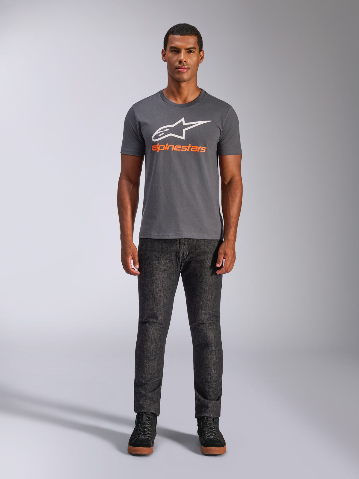 Alpinestars Always 2.0 CSF Tee, Short Sleeve T-Shirt, Charcoal Gray with White Logo and Orange Text, worn by model with dark jeans, Casual Motorsport Streetwear