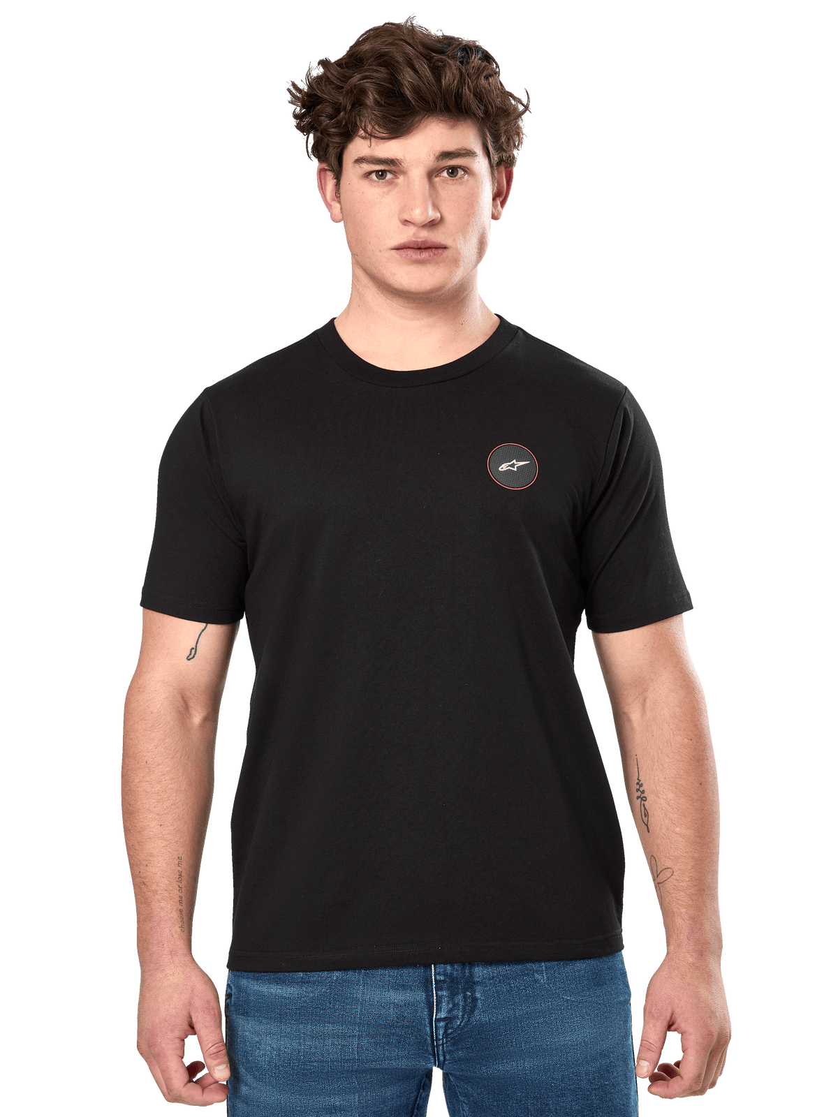 Alpinestars Dot Carbon CSF Tee, t-shirt à manches courtes, noir, petit logo circulaire sur la poitrine avec Astar blanc et bordure rouge, porté par un mannequin avec un jean bleu, style streetwear motorsport décontracté