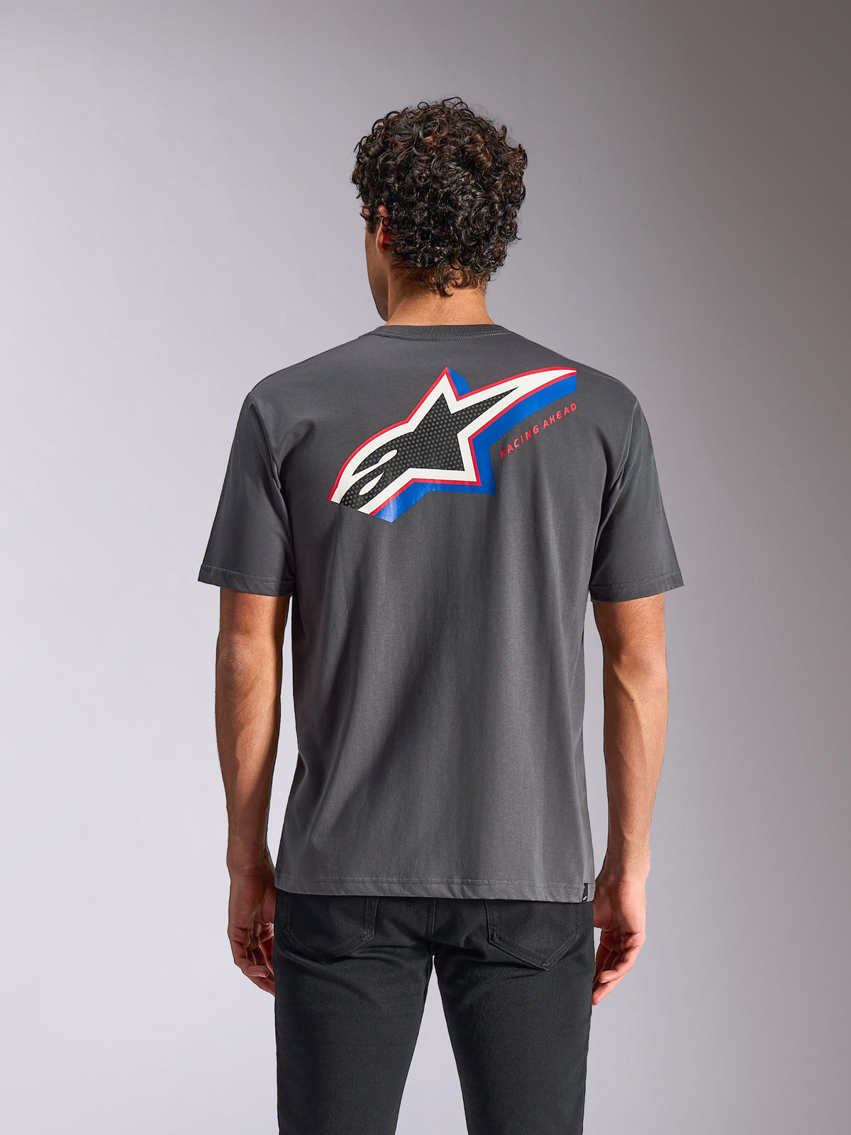T-shirt Alpinestars Angler CSF, t-shirt à manches courtes, gris anthracite, vue de dos présentant un grand logo Astars avec des accents bleus et rouges et le texte « RACING AHEAD », style streetwear décontracté