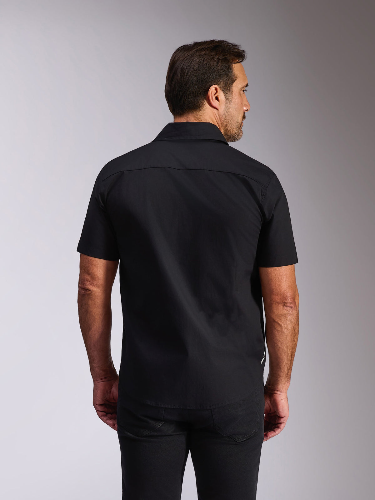 Chemise Strive Woven Alpinestars, chemise à manches courtes boutonnée noire, vue arrière montrant l'empiècement dos et la coupe ajustée, streetwear décontracté inspiré du motorsport