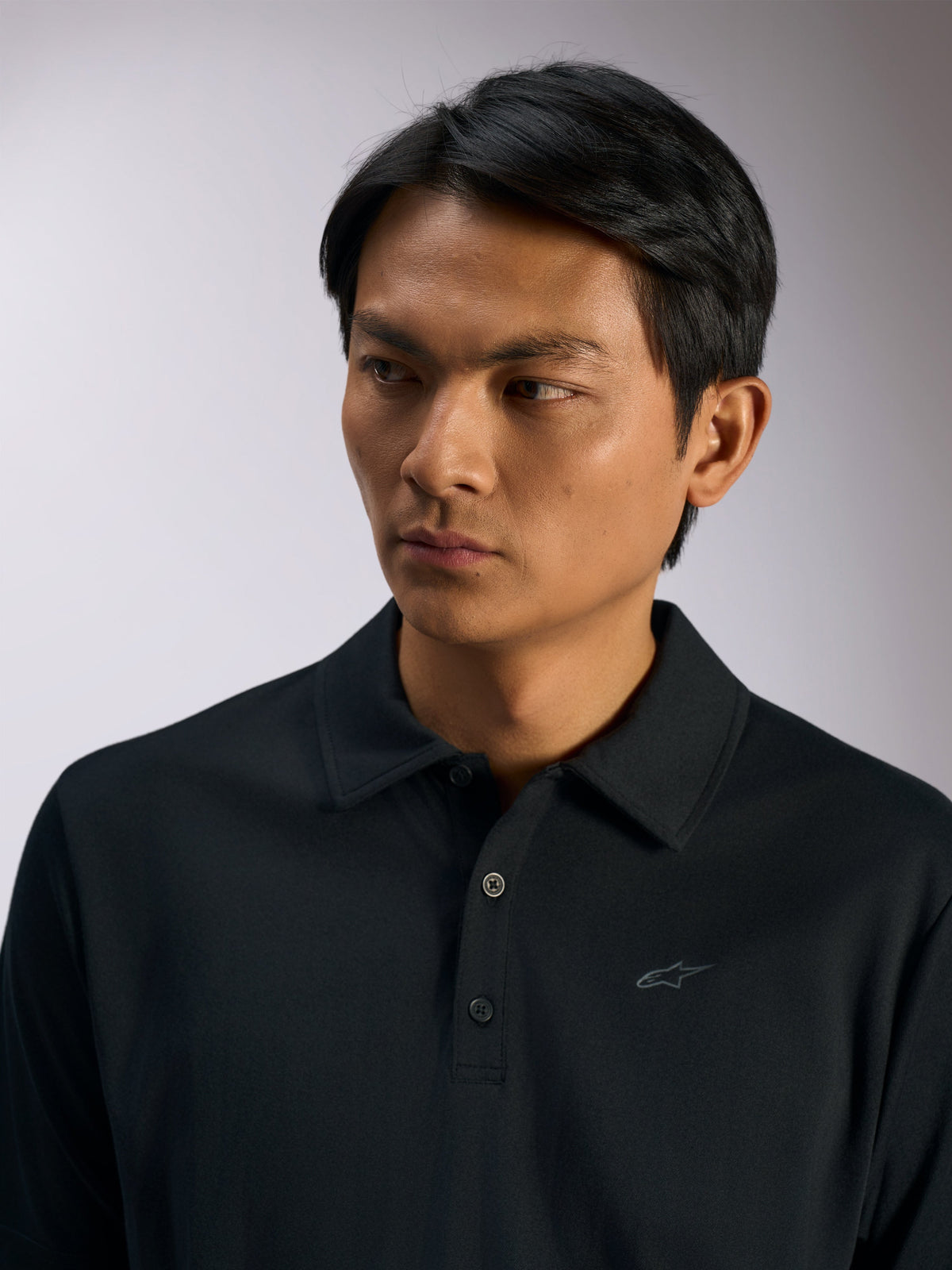 Polo Sport Impetus Alpinestars, polo sportswear noir, tissu en maille imitation avec patte de boutonnage à trois boutons et col en tissu, logo Astars discret sur la poitrine, vêtement décontracté de style motorsport lifestyle