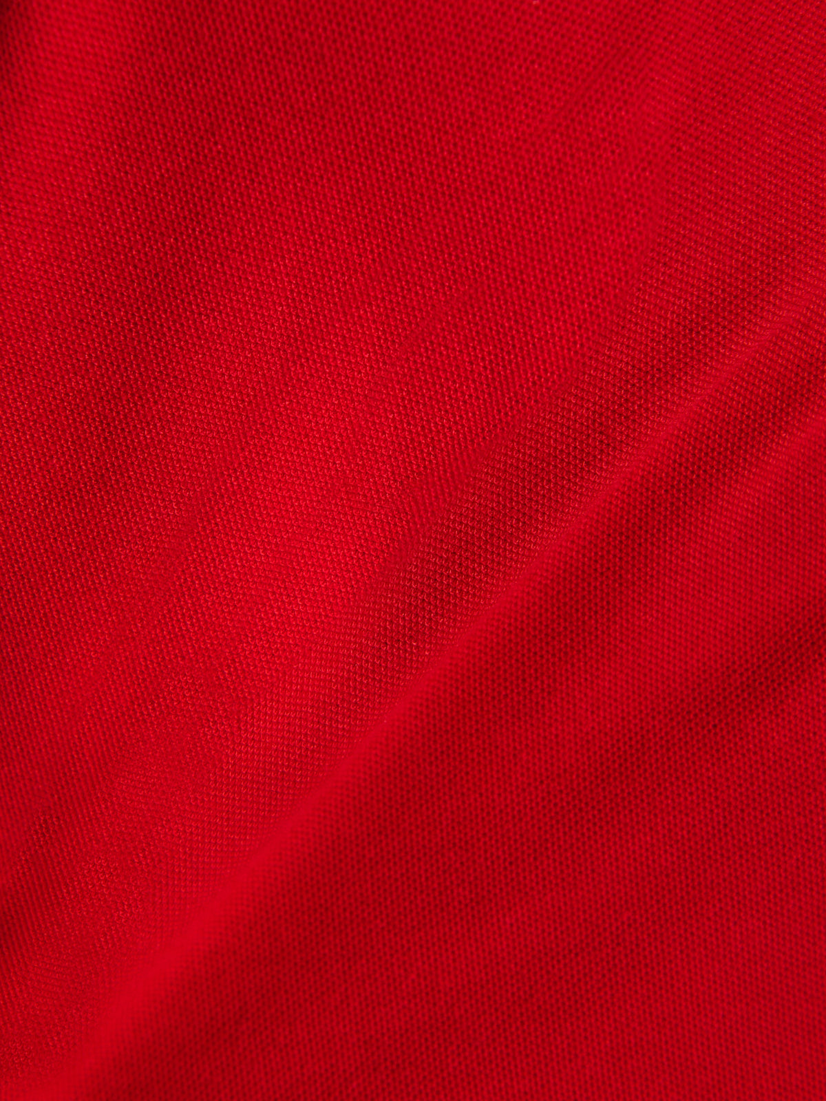 Polo Classique Endeavor Alpinestars, gros plan sur le tissu piqué rouge, maille texturée, mélange coton-polyester, vêtement sportswear motorsport décontracté