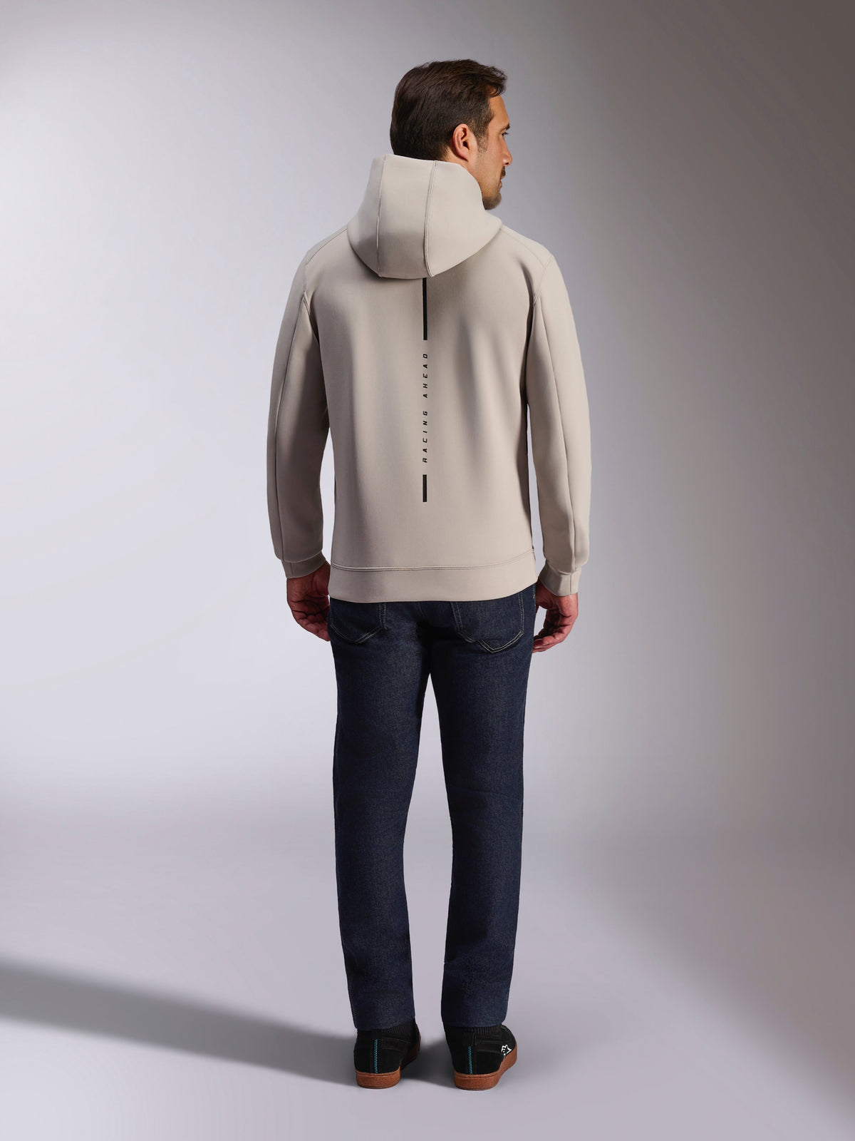 Sweat à capuche Alpinestars Insight, vue de dos, gris ciment, bande noire verticale avec l'inscription 'RACING AHEAD', polaire double face, streetwear décontracté inspiré du sport automobile
