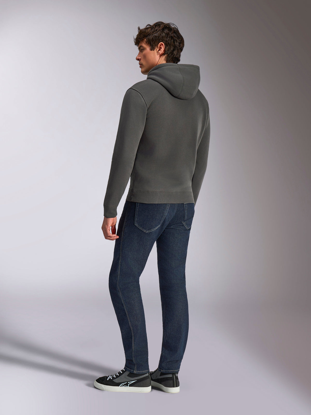 Sweat à capuche Alpinestars Ellipsoid, sportswear décontracté, gris gunmetal, vue de dos sur un mannequin homme, capuche à cordon de serrage, manches longues, poignets et ourlet côtelés, porté avec un jean foncé et des baskets