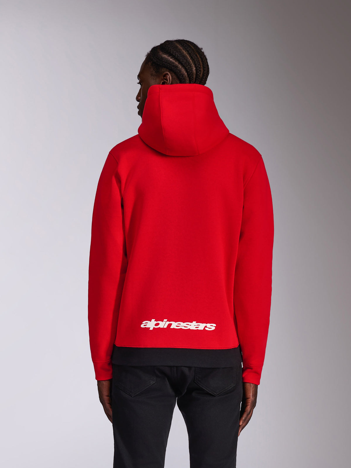 Alpinestars Parallel Hoodie, rear view, red with black ribbed hem, white Alpinestars word logo on the lower back, casual motorsport-inspired streetwear