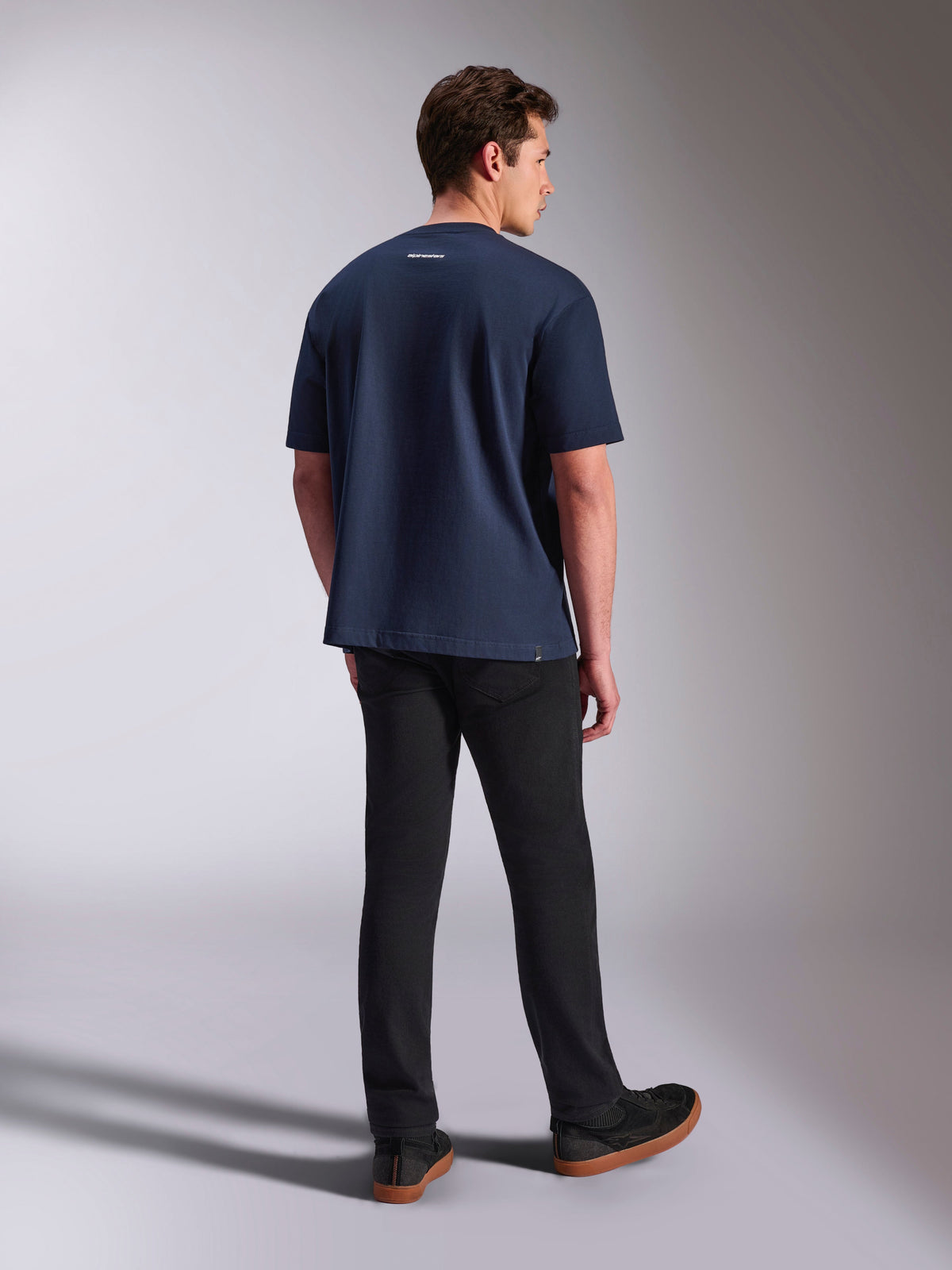 T-shirt Alpinestars Focused Oversized CSF, t-shirt à manches courtes, bleu marine, vue de dos montrant un petit logo Alpinestars blanc sur la nuque, porté avec un pantalon noir, vêtements lifestyle décontractés