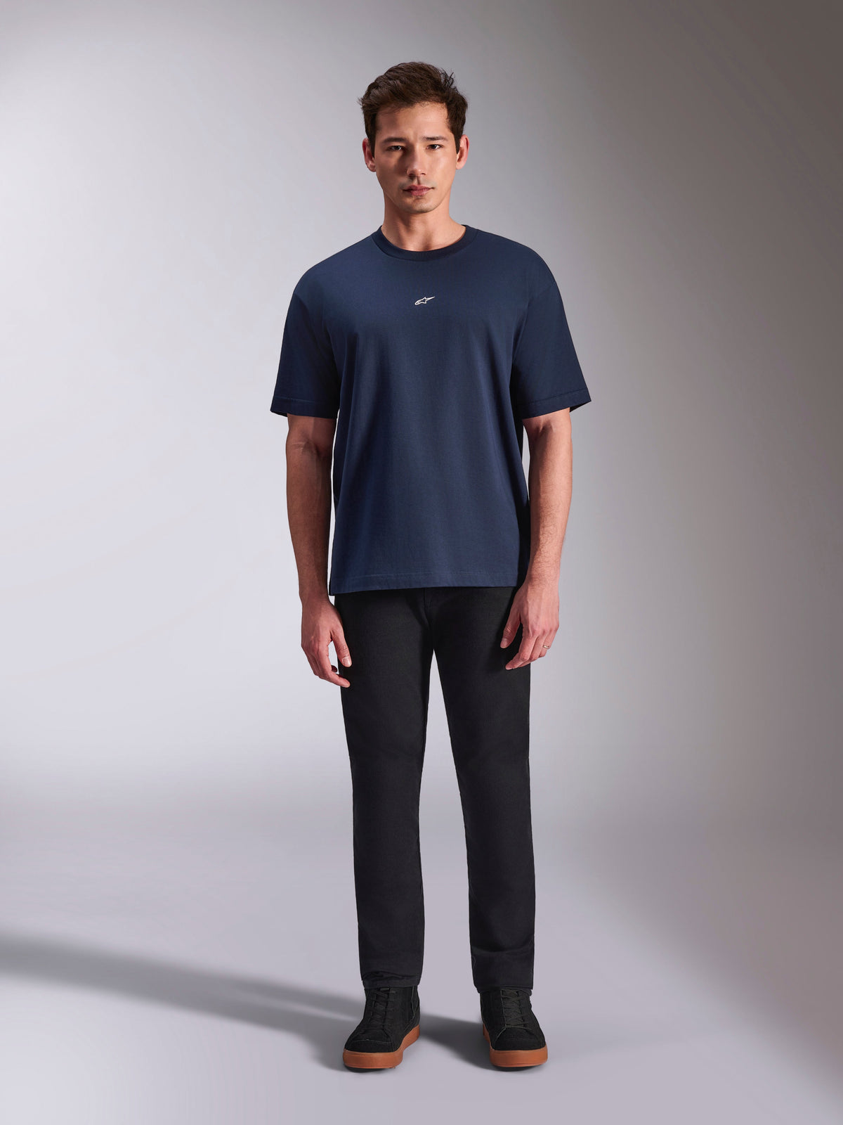 T-shirt Alpinestars Focused Oversized CSF, t-shirt à manches courtes bleu marine avec petit logo Astars blanc sur la poitrine, coupe surdimensionnée, porté avec un pantalon noir et des baskets noires, style streetwear décontracté