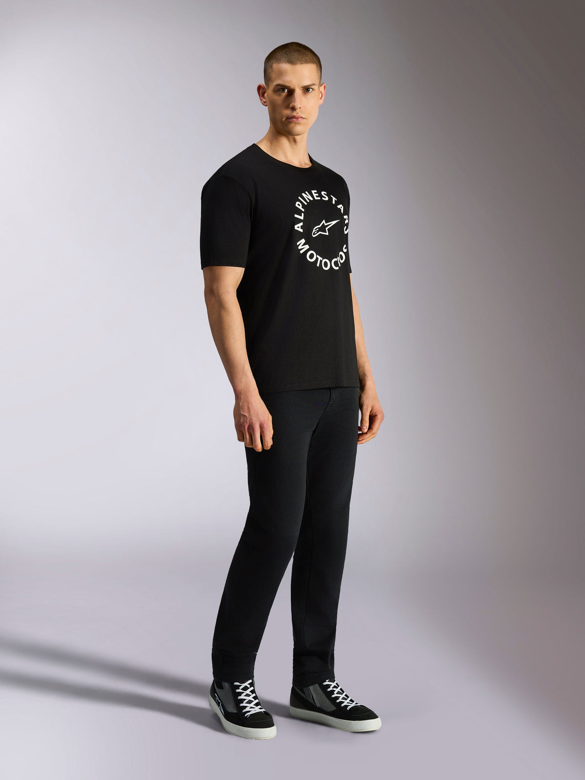 Alpinestars MX CSF Tee, Short Sleeve T-Shirt, Black, White circular Alpinestars Motocross graphic on chest, worn by model with black pants and sneakers, casual motorsport streetwear