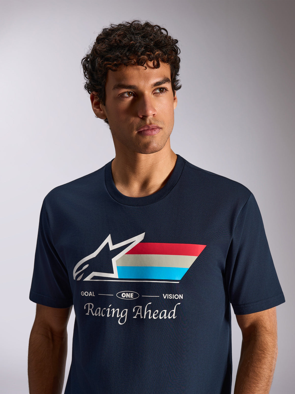 T-shirt Alpinestars Trifecta CSF, t-shirt à manches courtes, bleu marine, logo Astars blanc avec rayures tricolores et texte 'Racing Ahead', portrait lifestyle décontracté motorsport