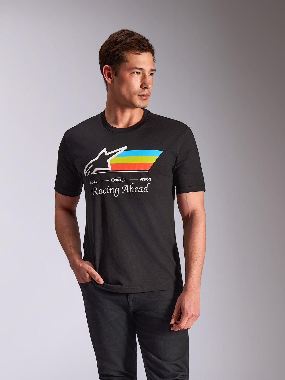 Alpinestars Trifecta CSF Tee, Short Sleeve T-Shirt, Black, featuring a white Astars logo with cyan, lime green, and orange horizontal stripes, 'Racing Ahead' text graphic, casual motorsport-inspired streetwear worn by a model