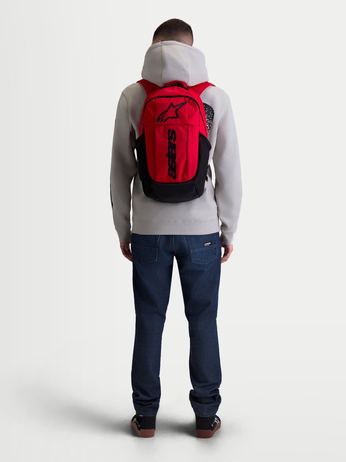 Alpinestars sac à dos GFX Boss, sac à dos de sportswear urbain de 20L, rouge et noir, vue de dos sur modèle, construction en polyester 600D durable avec manchon interne pour ordinateur portable et bretelles en maille aérée rembourrées.