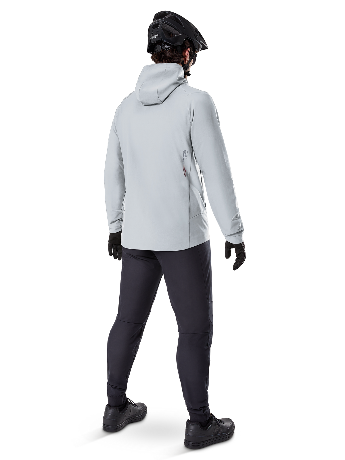 Veste thermique Alpinestars A-Dura en Titanium, vue arrière d'un cycliste portant une veste thermique à capuche gris clair, accompagnée d'un casque de VTT noir, de gants noirs et d'un pantalon gris foncé, équipement de VTT fonctionnel.