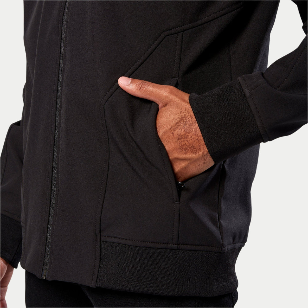 Alpinestars Primary Jacket, Black Softshell Jacket, close-up detail of hand pocket, ribbed cuff, and ribbed hem, casual motorsport-inspired technical outerwear
