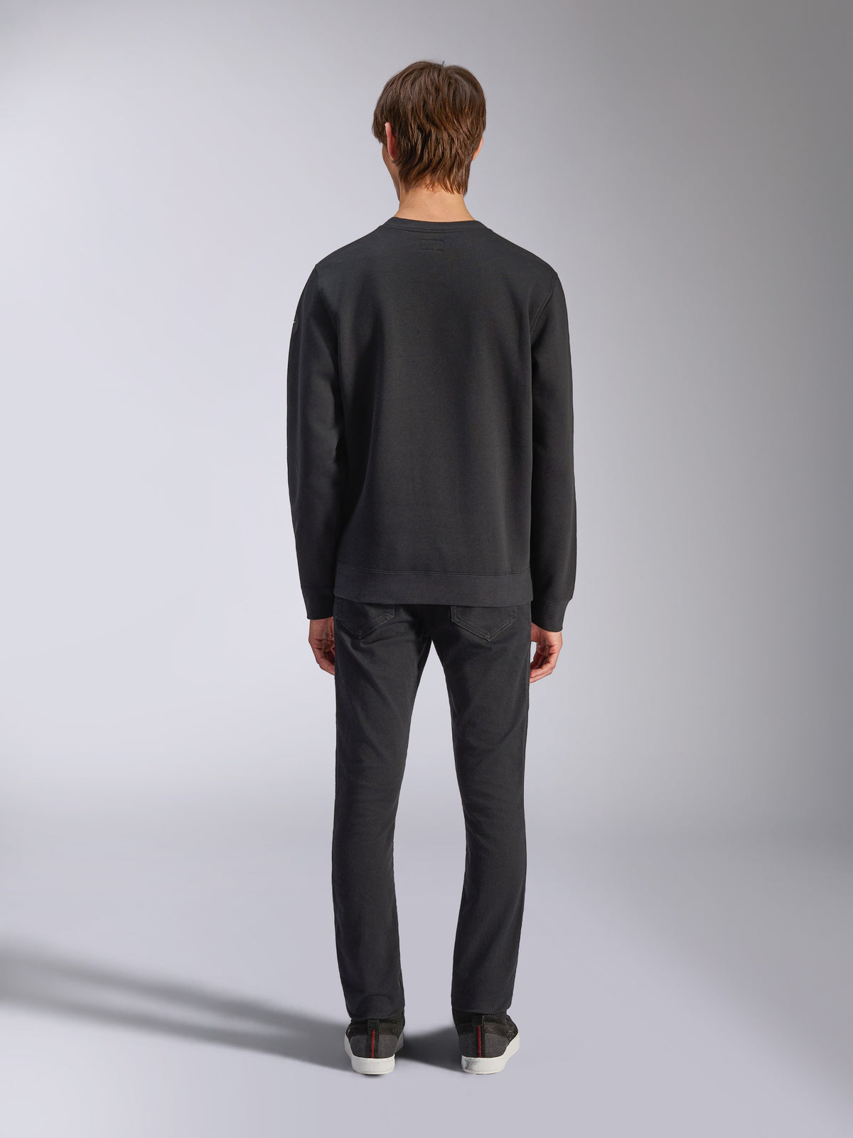 Alpinestars Bettern Crew, sweat à col rond noir, vue de dos sur modèle, col et ourlet côtelés, streetwear décontracté inspiré du sport automobile