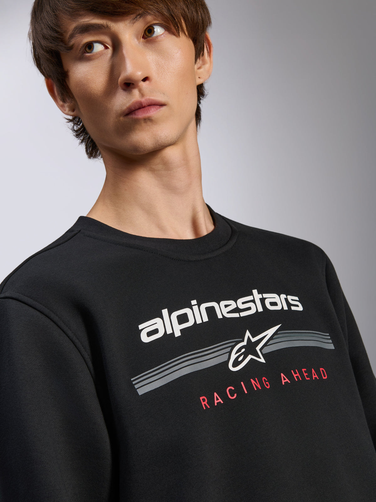 Pull Alpinestars Bettern Crew, sweatshirt noir, logo Alpinestars blanc avec inscription rouge 'Racing Ahead', col rond, streetwear décontracté inspiré du sport automobile