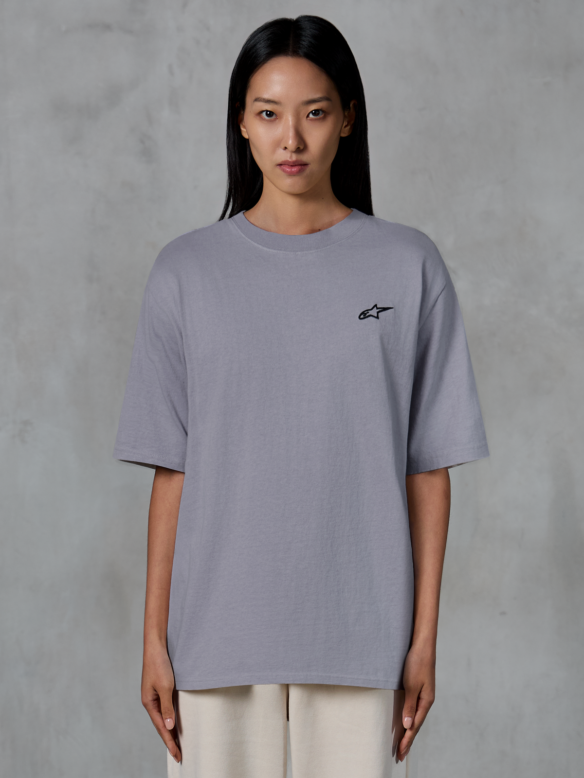 Alpinestars Essentials Ageless SS Tee, t-shirt à manches courtes, argent, avec un petit logo Alpinestars noir sur la poitrine, coupe décontractée et contemporaine, coton biologique, style streetwear décontracté porté par un mannequin