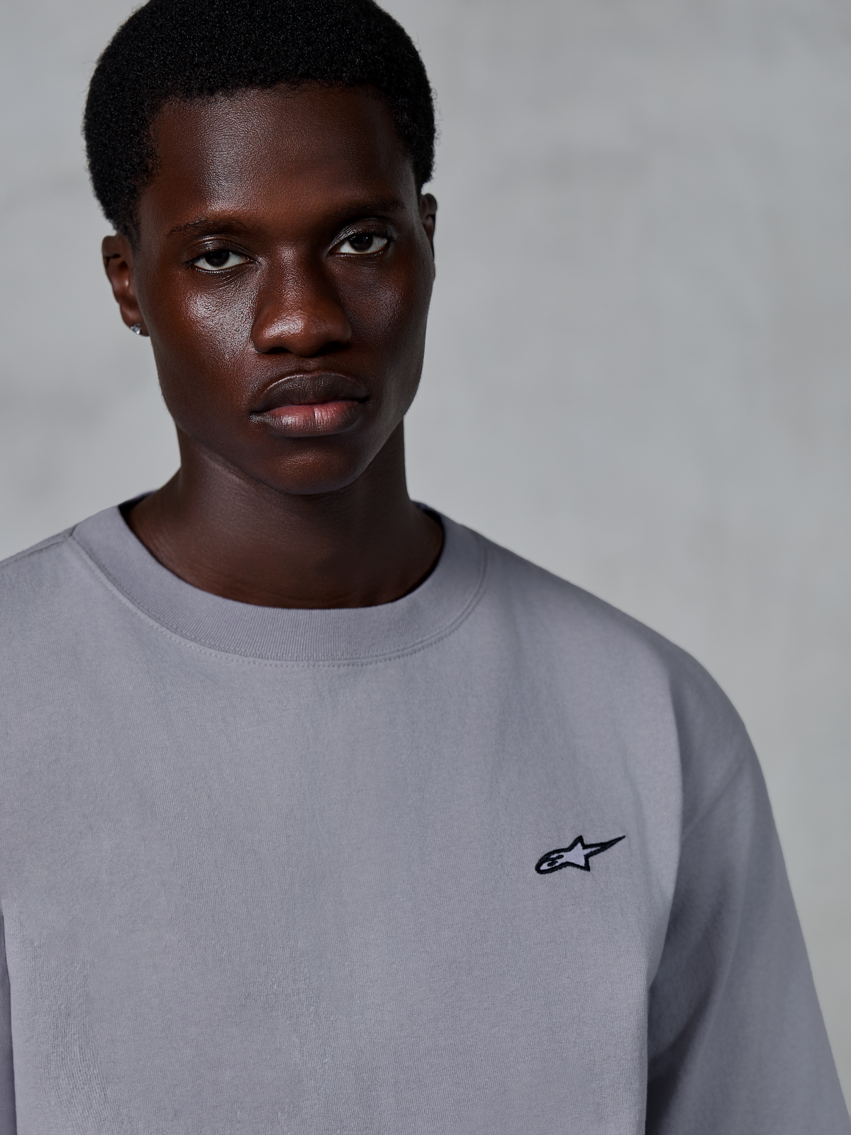 Alpinestars Essentials Ageless SS Tee, t-shirt à manches courtes, Silver, avec un petit logo étoile noir sur la poitrine, porté par un mannequin, style streetwear décontracté