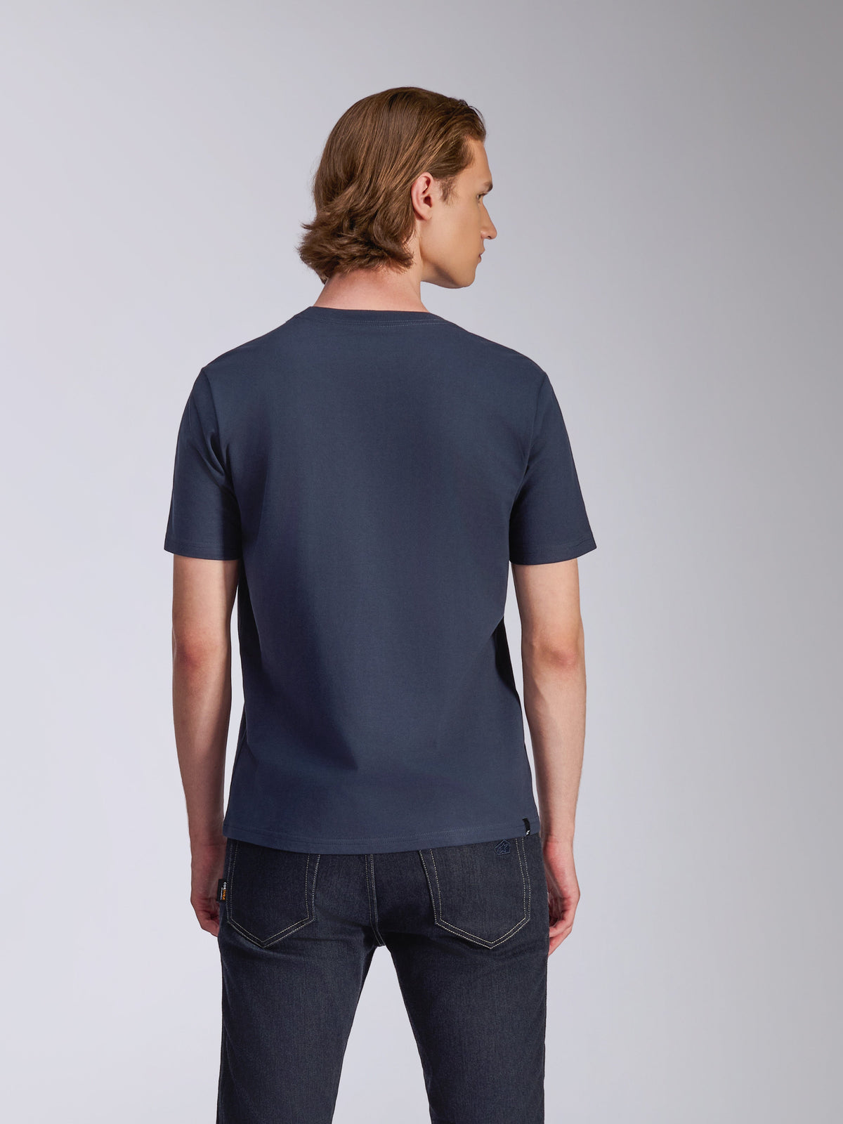 Alpinestars Fasting CSF Tee, t-shirt à manches courtes, bleu marine, vue de dos, porté par un mannequin avec un jean foncé, streetwear décontracté inspiré du sport automobile