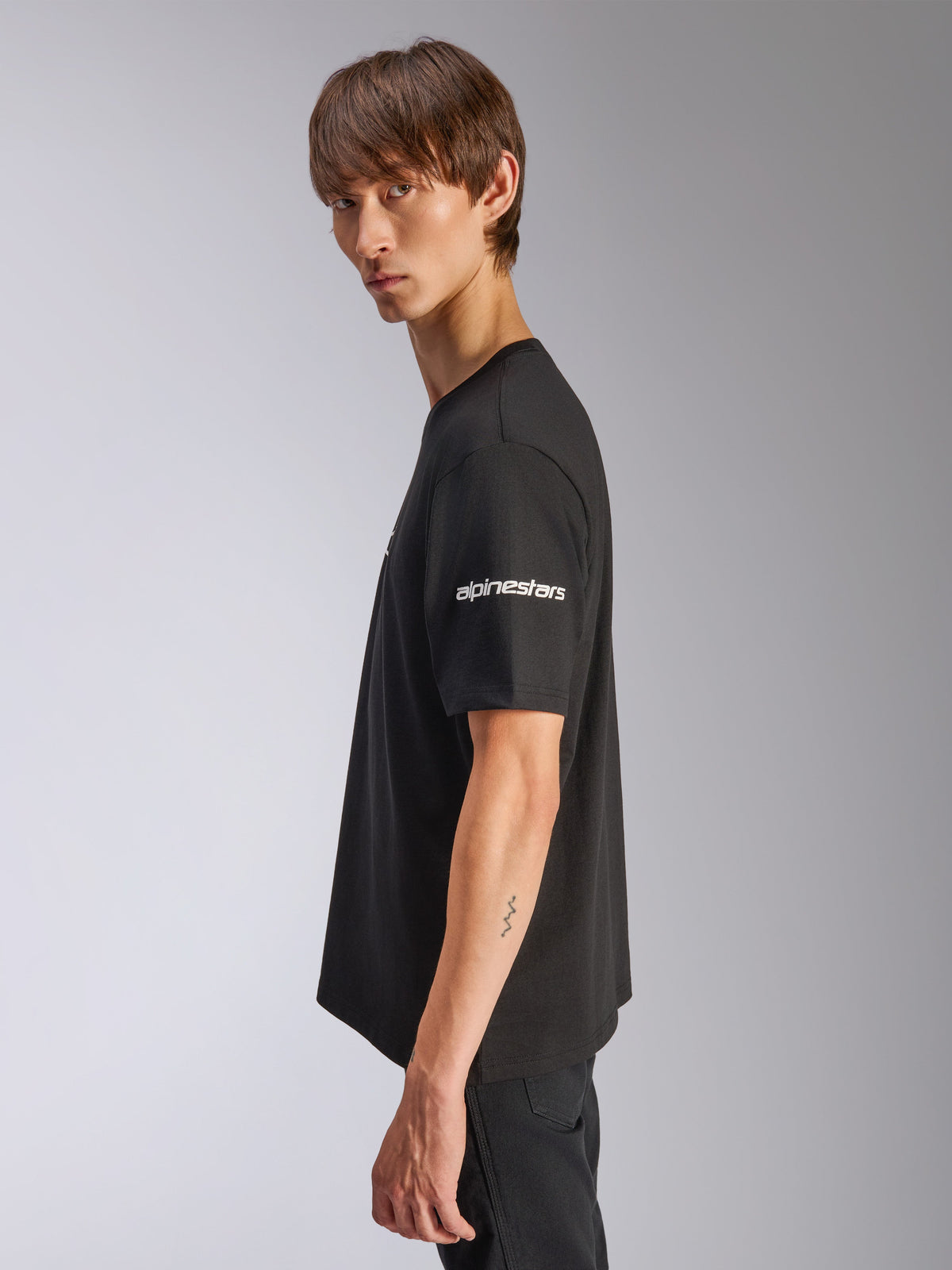 Alpinestars Frontal CSF Tee, Short Sleeve T-Shirt, Black, white Alpinestars logo on sleeve, worn by model in profile view, casual motorsport performance streetwear