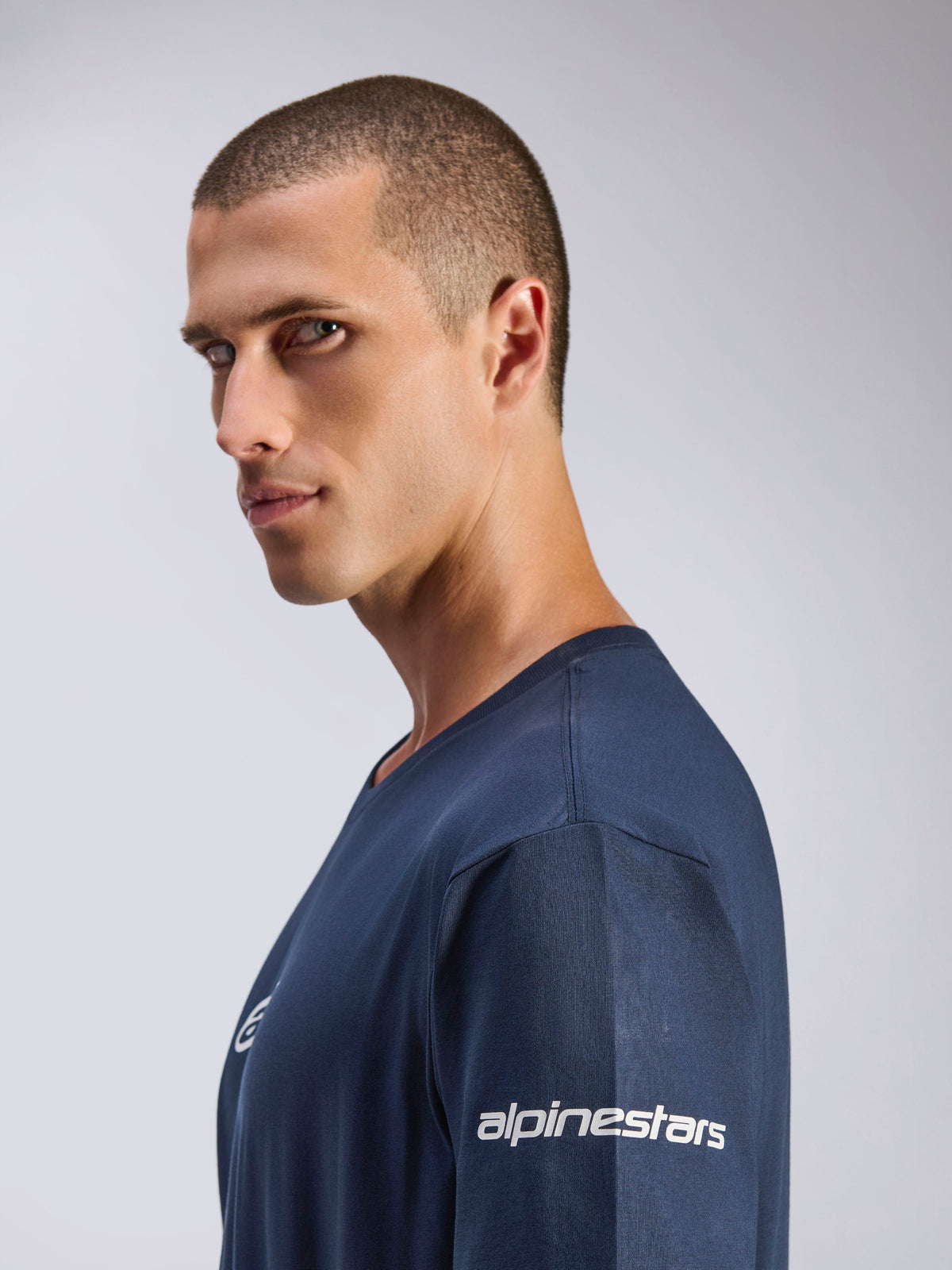 Alpinestars Frontal CSF Tee, t-shirt à manches courtes, bleu marine, vue de profil d'un mannequin homme, logo Alpinestars blanc sur la manche, tissu performant évacuant l'humidité, style motorsport décontracté