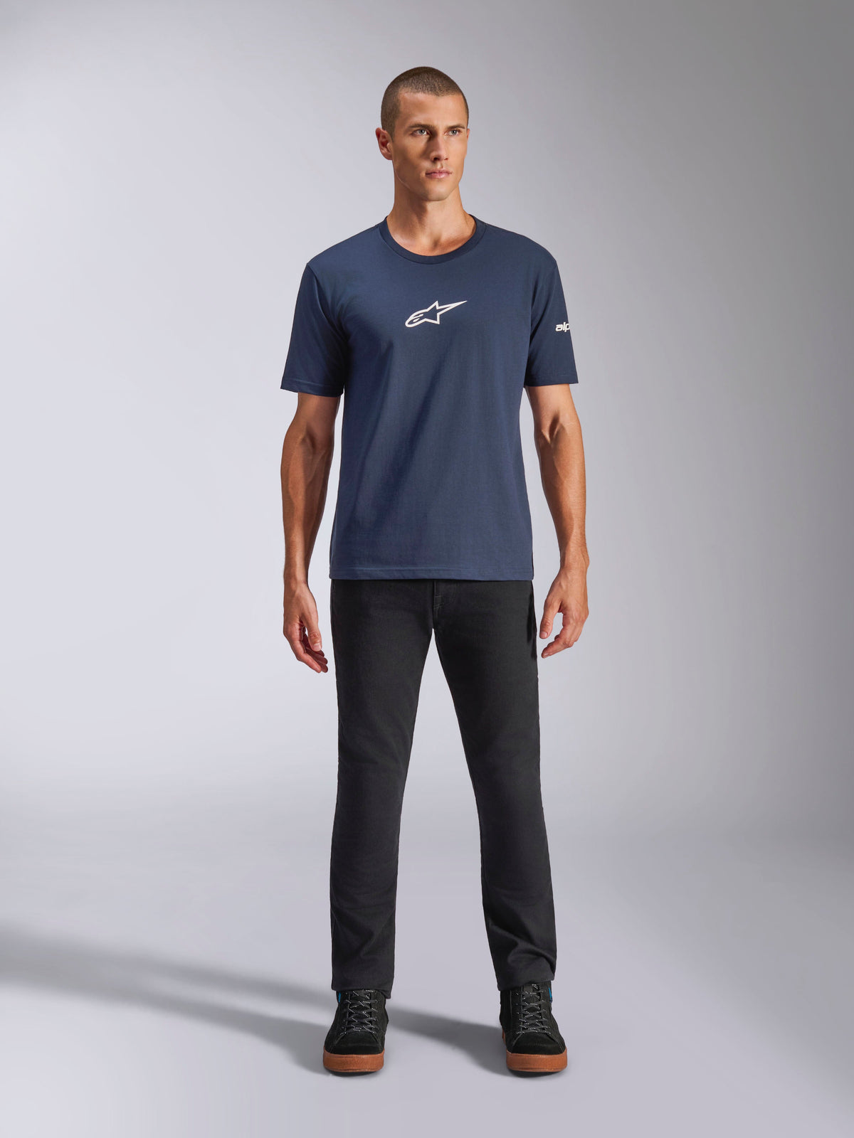 Alpinestars Frontal CSF Tee, t-shirt à manches courtes, bleu marine, logo étoile Alpinestars blanc sur la poitrine, porté avec un pantalon noir et des baskets, sportswear de performance décontracté
