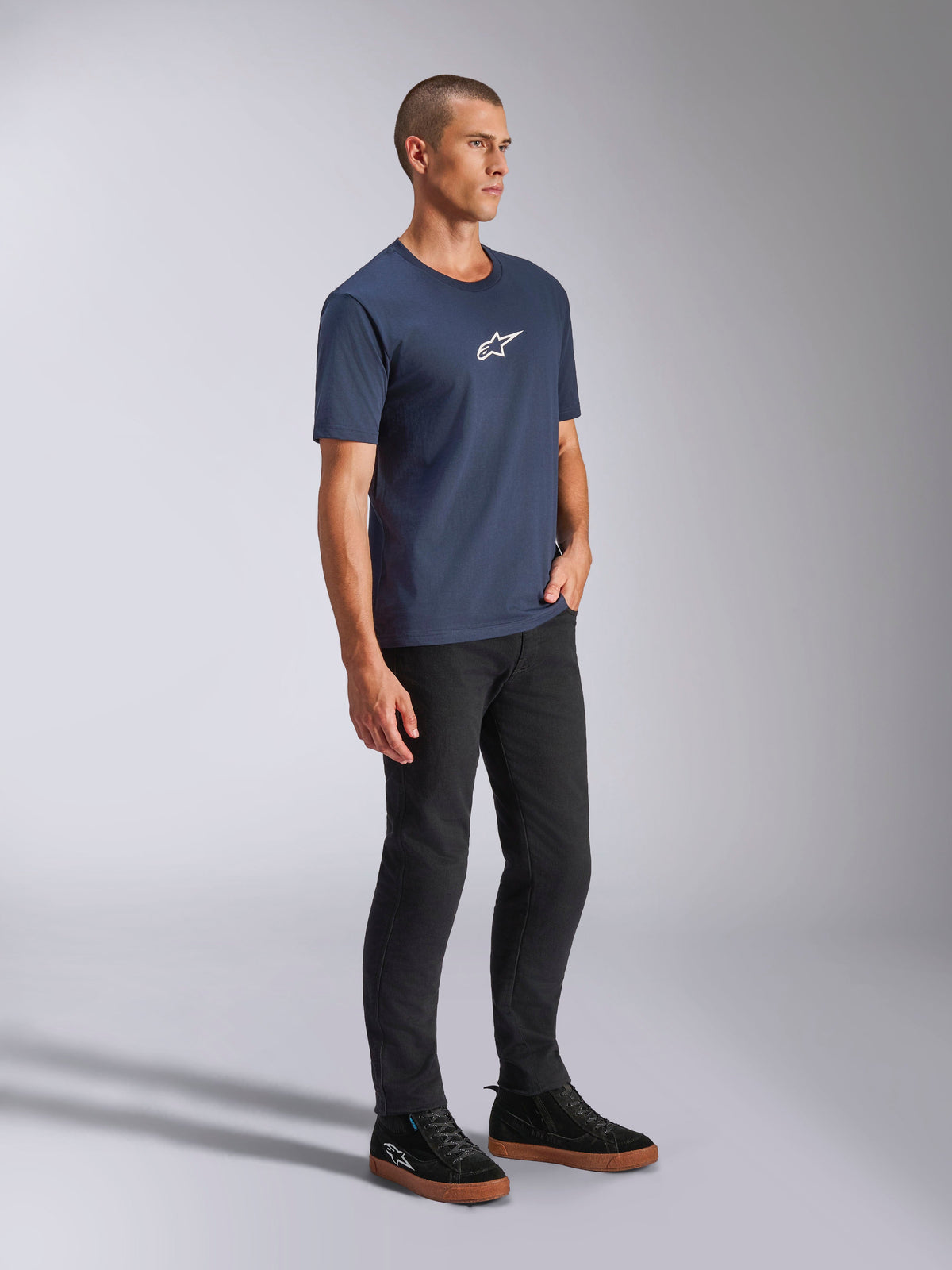 T-shirt Alpinestars Frontal CSF, à manches courtes, bleu marine, petit logo Astars blanc sur la poitrine, porté avec un pantalon noir et des baskets, streetwear décontracté et performant