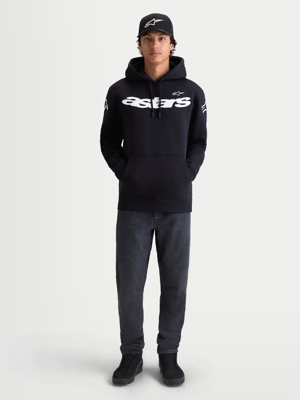 Alpinestars Sweat À Capuche Velocifier, sweat à capuche de sportswear pour homme, noir et blanc, logo Astars blanc sur le devant et les épaules, polaire premium, porté par un modèle avec une casquette pour un look décontracté