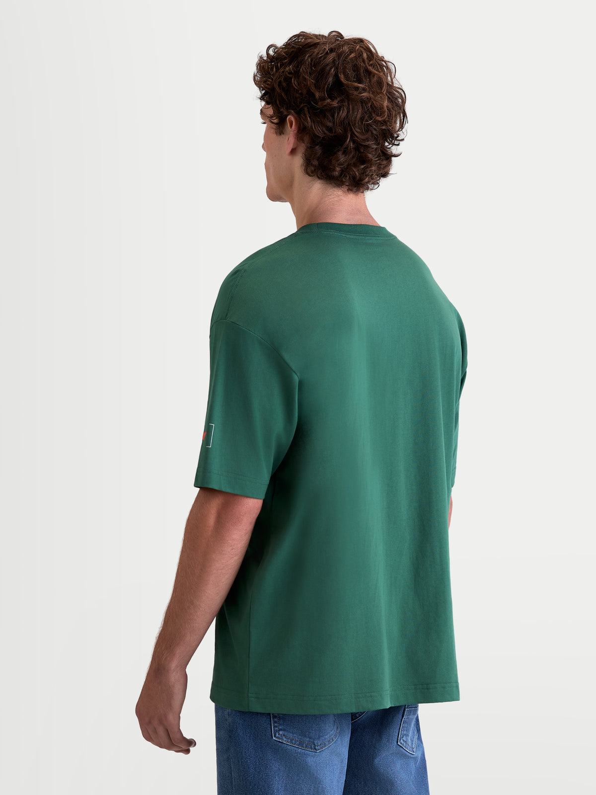 Alpinestars T-Shirt Infinity Oversized CSF, t-shirt sportswear à manches courtes pour homme, vert, mélange coton et polyester, coupe oversized, vue de dos sur modèle montrant le détail du logo sur la manche