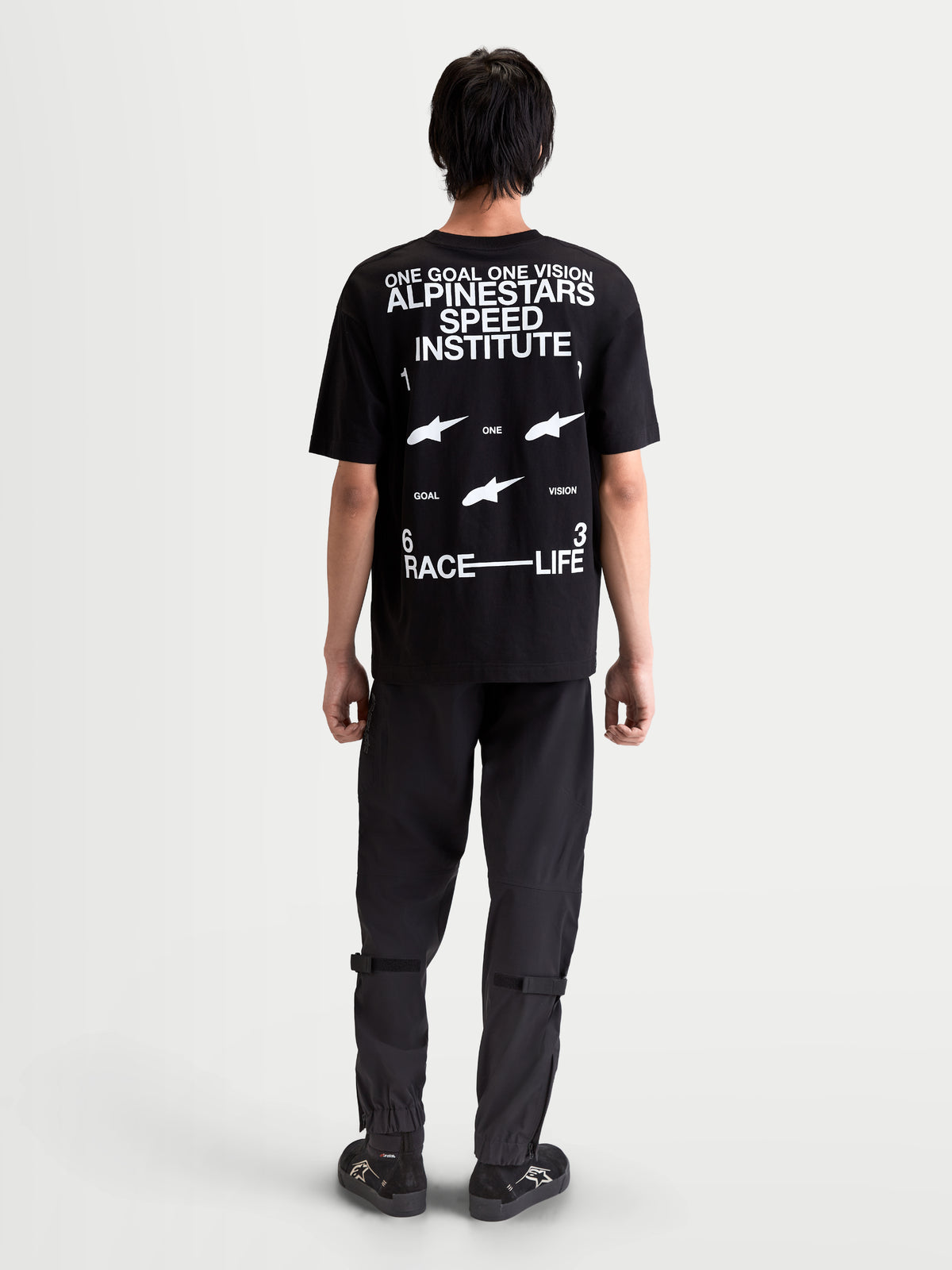 Alpinestars T-Shirt Institute Oversized CSF, t-shirt sportswear à manches courtes, noir avec logos blancs au dos Alpinestars Speed Institute et One Goal One Vision, coupe oversize décontractée, vue de dos porté par un modèle