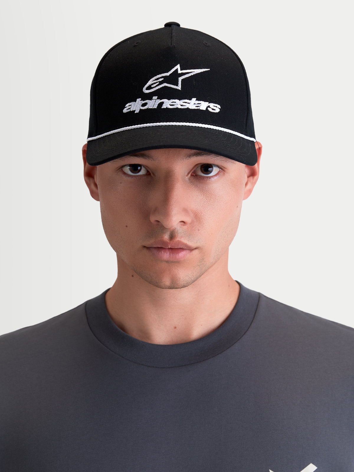 Alpinestars Casquette Combo Logo Snapback, casquette de sportswear moto unisexe, noire et blanche, avec visière courbée, couronne structurée et logo Astars brodé, 100 % sergé de coton, vue de face sur modèle.