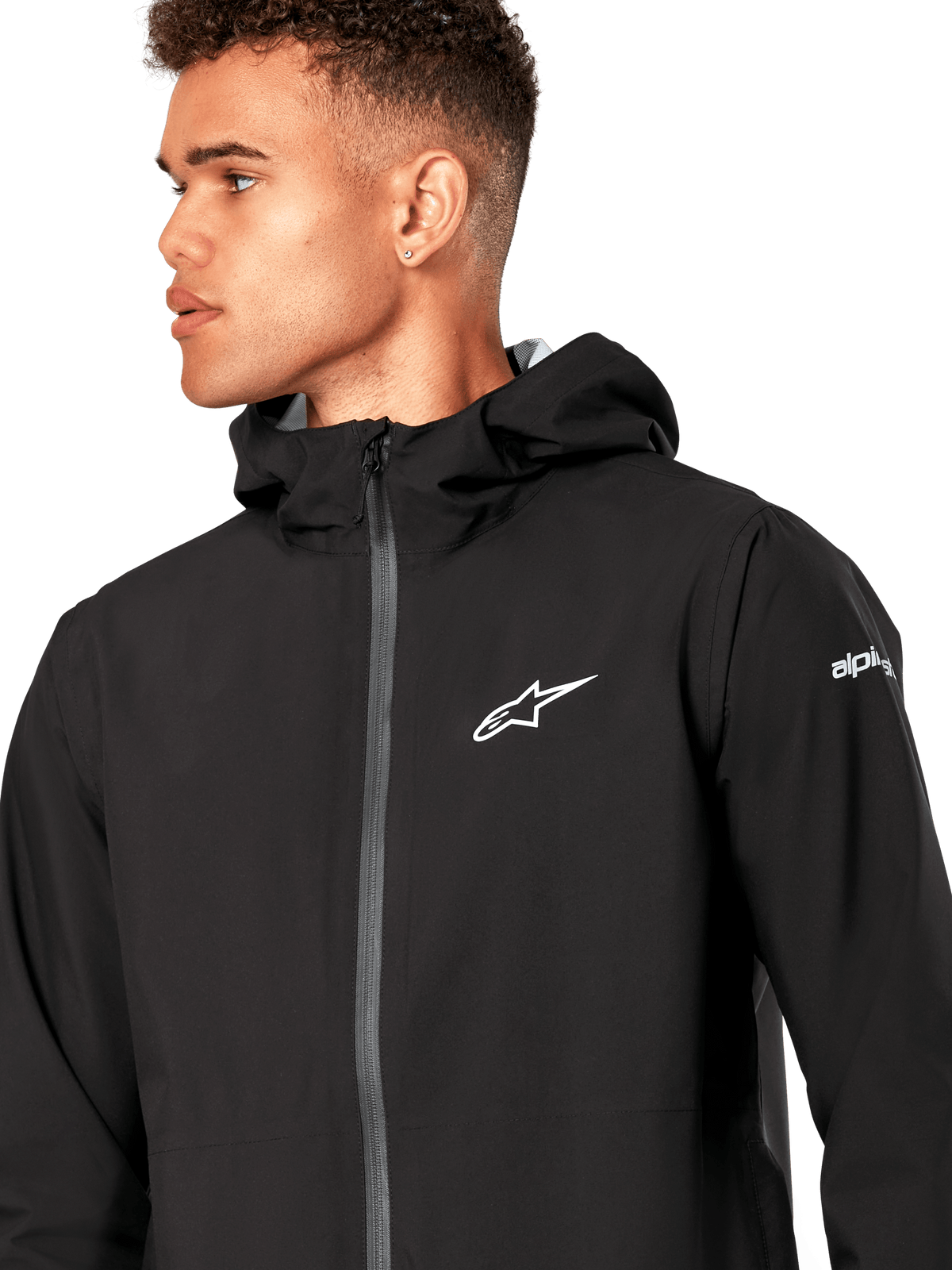 Alpinestars Kascade Rain Jacket, Black Rain Shell Jacket, featuring a white star logo on the chest, fixed hood, and coated reverse coil front zipper, casual motorsport-inspired performance outerwear