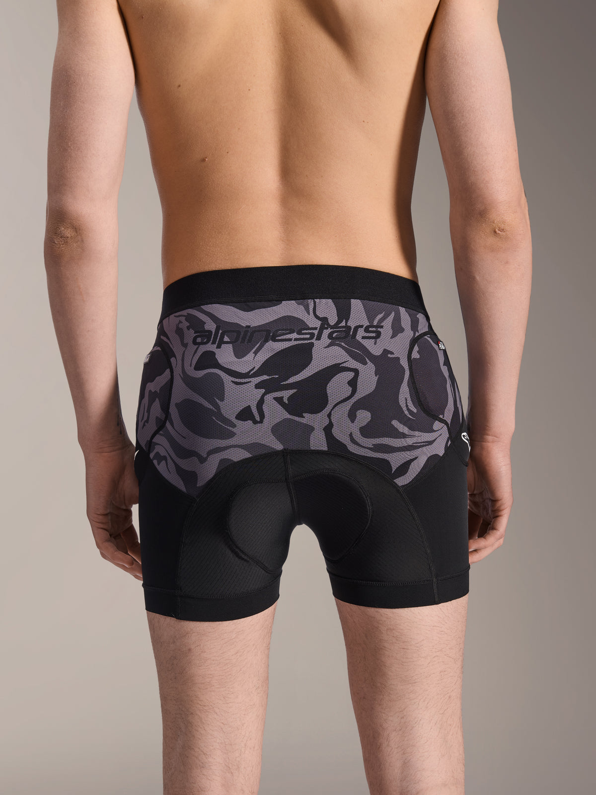 Alpinestars A-Motion Plasma Protection Boxers, MTB Protection Shorts, Black Camo, rear view worn by a model, featuring Alpinestars logo on a camo mesh panel, integrated chamois pad and hip protection pockets, breathable base layer for off-road cycling