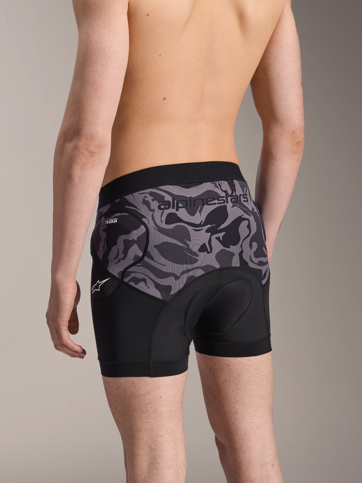 Alpinestars A-Motion Plasma Protection Boxers, Black Camo cycling protection shorts, rear view showing ergonomic design with Nucleon Plasma hip protection and chamois pad, breathable mesh material with Alpinestars logo on waistband