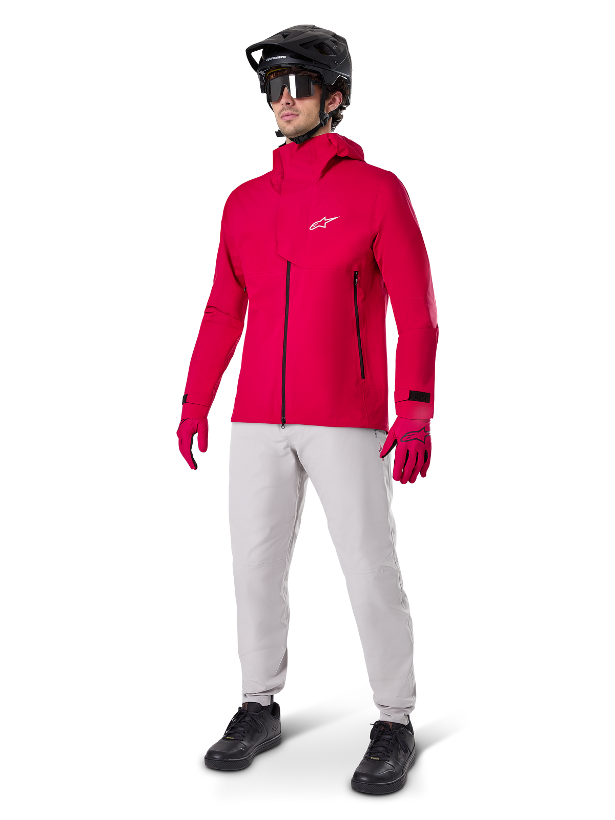 Mannequin portant le pantalon imperméable Alpinestars A-Dura en gris Titanium, associé à une veste imperméable rouge vif, des gants assortis, un casque de VTT noir avec masque et des chaussures noires, équipement complet de VTT pour conditions humides