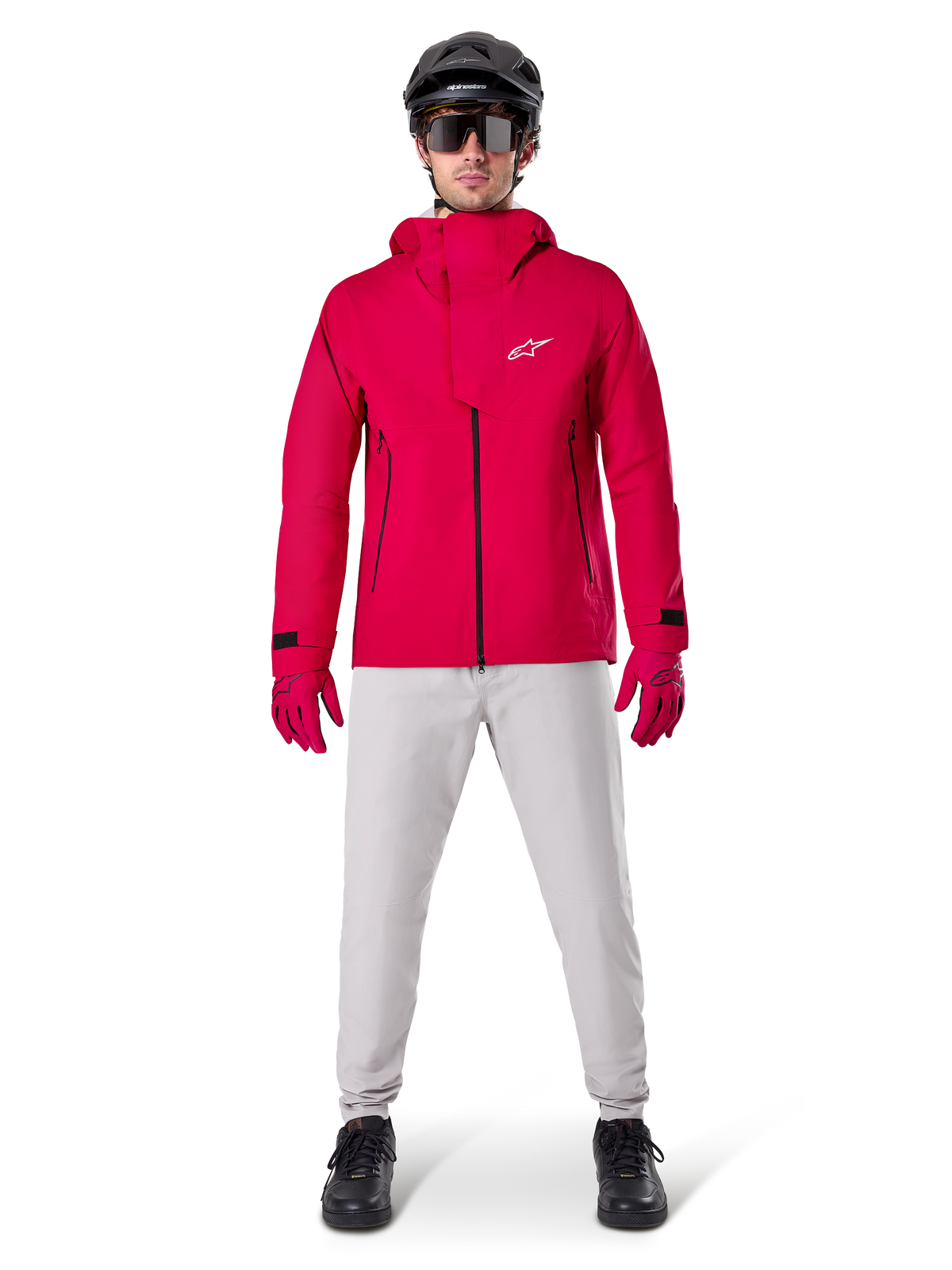Pantalon imperméable Alpinestars A-Dura, pantalon de VTT, gris titane, porté avec une veste à capuche rouge vif, des gants rouges et un casque de VTT noir, équipement de cyclisme imperméable professionnel pour conditions de sentiers humides