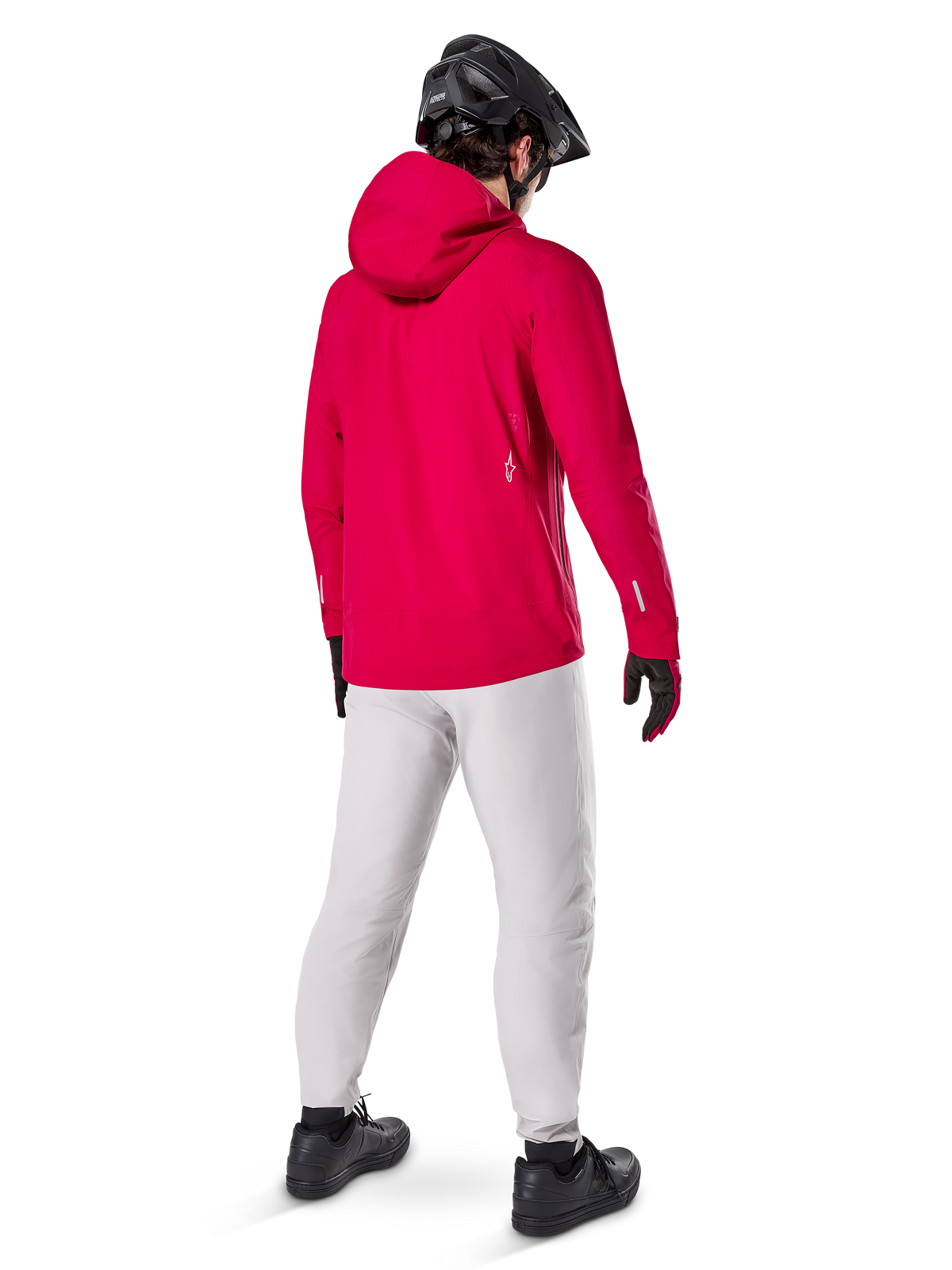 Pantalon imperméable Alpinestars A-Dura Titanium, vue arrière d'un cycliste portant un pantalon technique de VTT gris clair, veste à capuche rouge vif et casque noir, équipement imperméable durable pour le cyclisme par temps humide