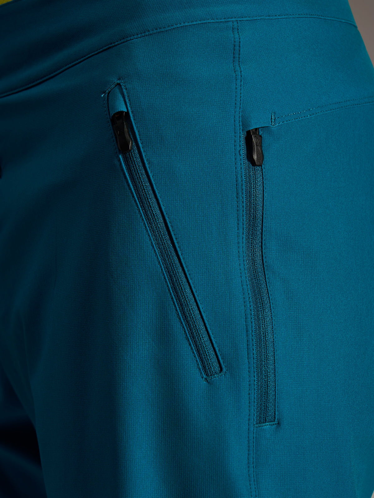 Short Alpinestars A-Dura Ride bleu-vert, deux poches zippées latérales et tissu robuste extensible 4 directions.