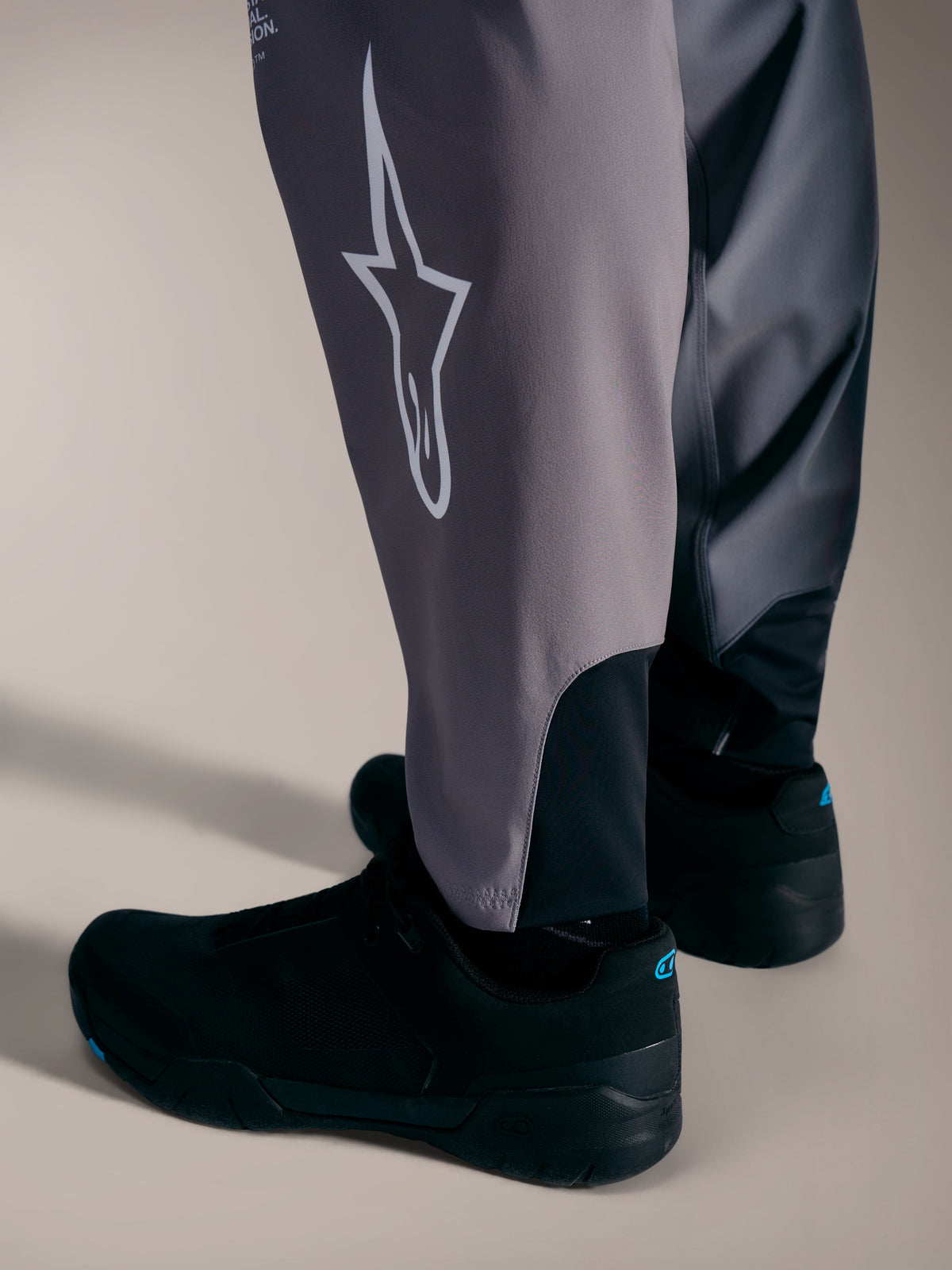 Pantalon A-Supra Elite gris avec logo Astars blanc et bas de jambe extensible pour la performance VTT.