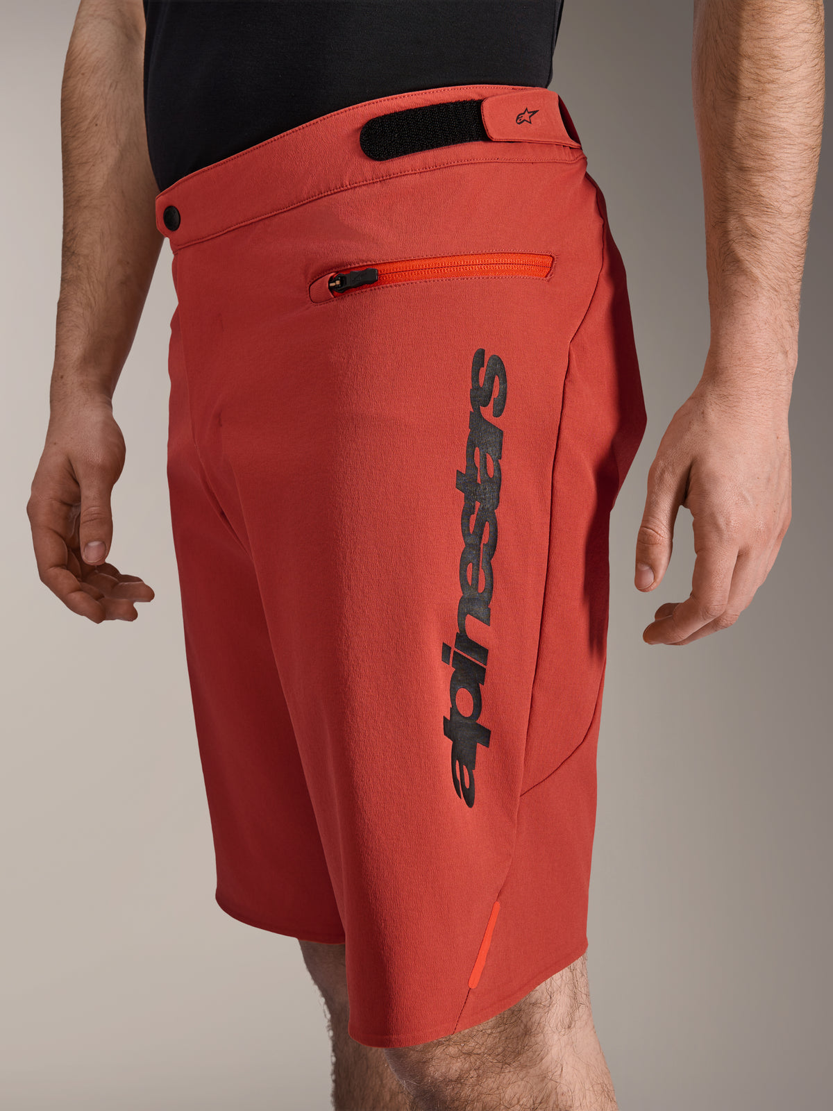 Short Alpinestars A-Dura Elite, short de VTT, orange foncé, avec logo Alpinestars noir vertical sur le côté, poche zippée et ajusteurs de taille à crochet et boucle, vêtement de cyclisme tout-terrain durable
