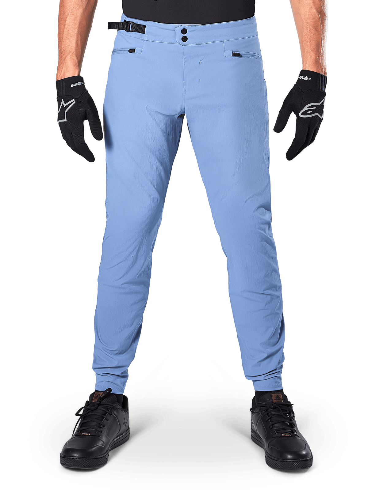 Pantalon Alpinestars A-Dura, pantalon de VTT, Infinity Blue, pantalon de VTT bleu clair avec double fermeture à pression et poches zippées, porté avec des gants noirs et des chaussures noires, coupe régulière avec bas de jambe élastiqués