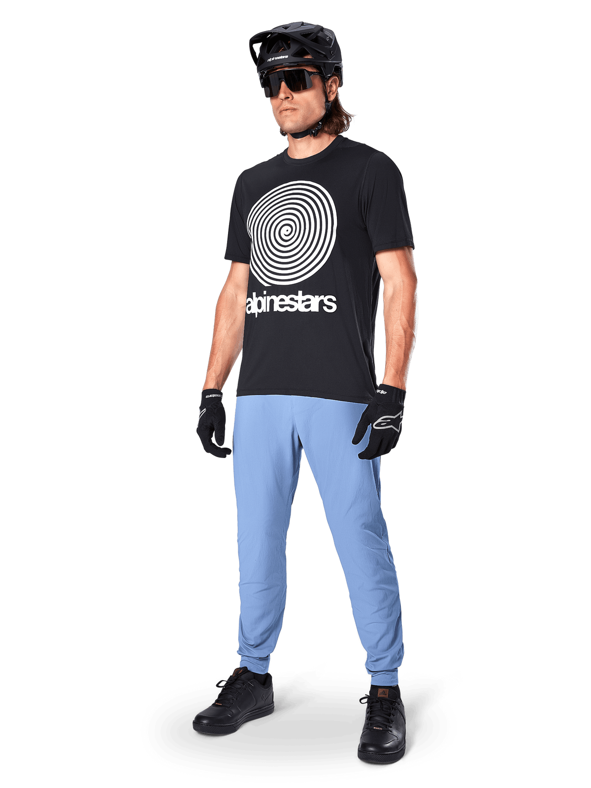 Alpinestars A-Dura Pants, pantalon de VTT, Bleu Infinity, porté avec un t-shirt graphique noir avec logo spirale blanc, casque noir, lunettes de soleil et gants noirs, équipement professionnel de VTT