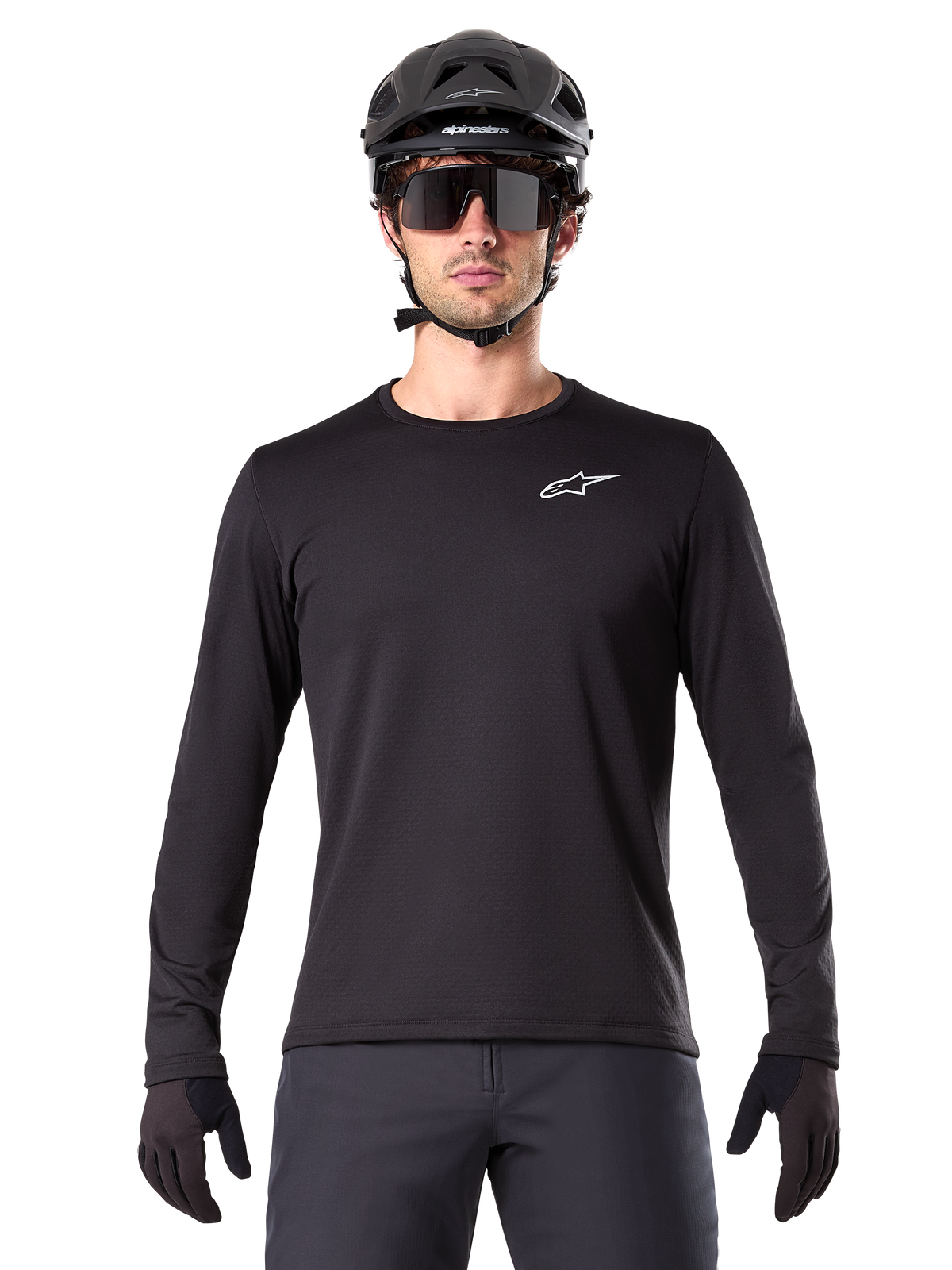 Maillot thermique Alpinestars A-Dura, maillot de VTT à manches longues noir, porté avec un casque noir et de larges lunettes de soleil, petit logo Alpinestars blanc sur la poitrine, coupe classique, équipement de cyclisme VTT