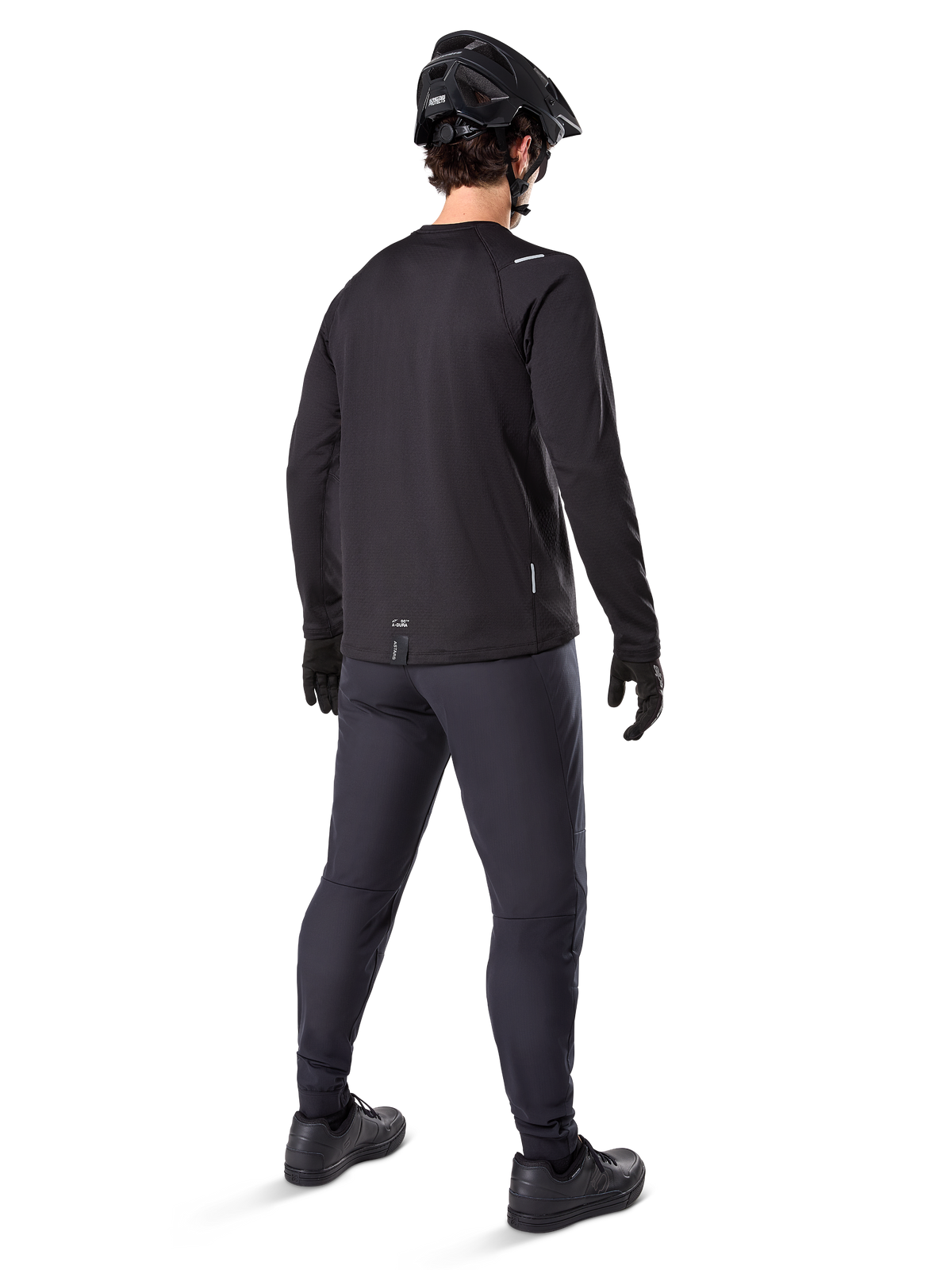 Maillot thermique Alpinestars A-Dura, maillot de cyclisme à manches longues pour homme, noir, vue arrière sur mannequin portant un casque de VTT noir, un pantalon gris foncé et des gants noirs, tenue de VTT professionnelle pour temps froid