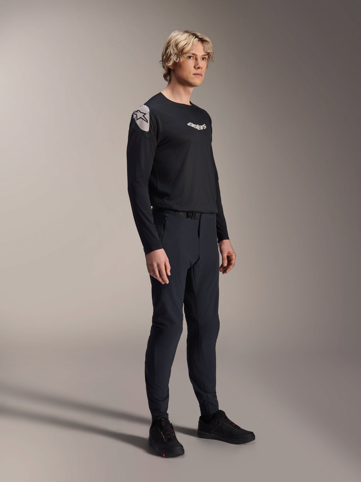 Mannequin portant le maillot à manches longues Alpinestars A-Aria Polartec Elite noir, associé à un pantalon de VTT technique noir assorti et des chaussures noires, tenue de cyclisme de performance pour le tout-terrain, photo en studio.