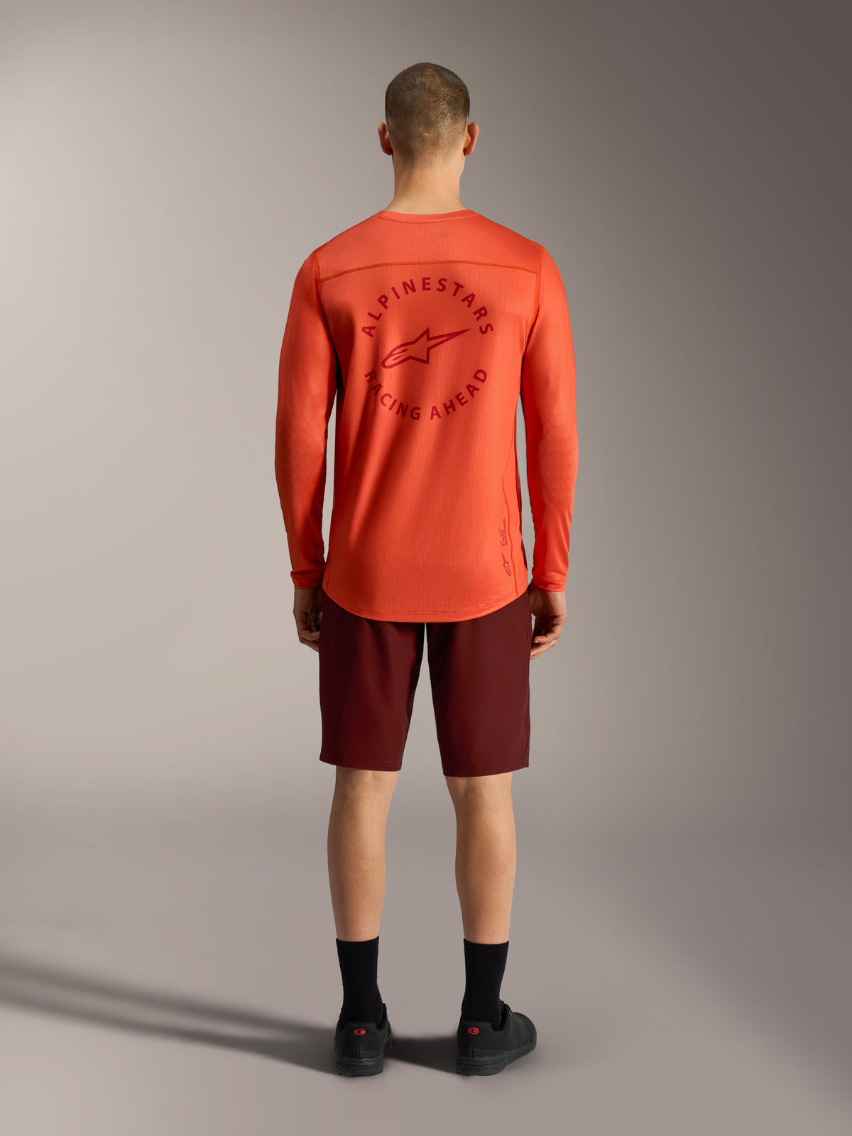 Maillot A-Dura Air orange et short Ride bordeaux, vue arrière de l'équipement de VTT performant Alpinestars.