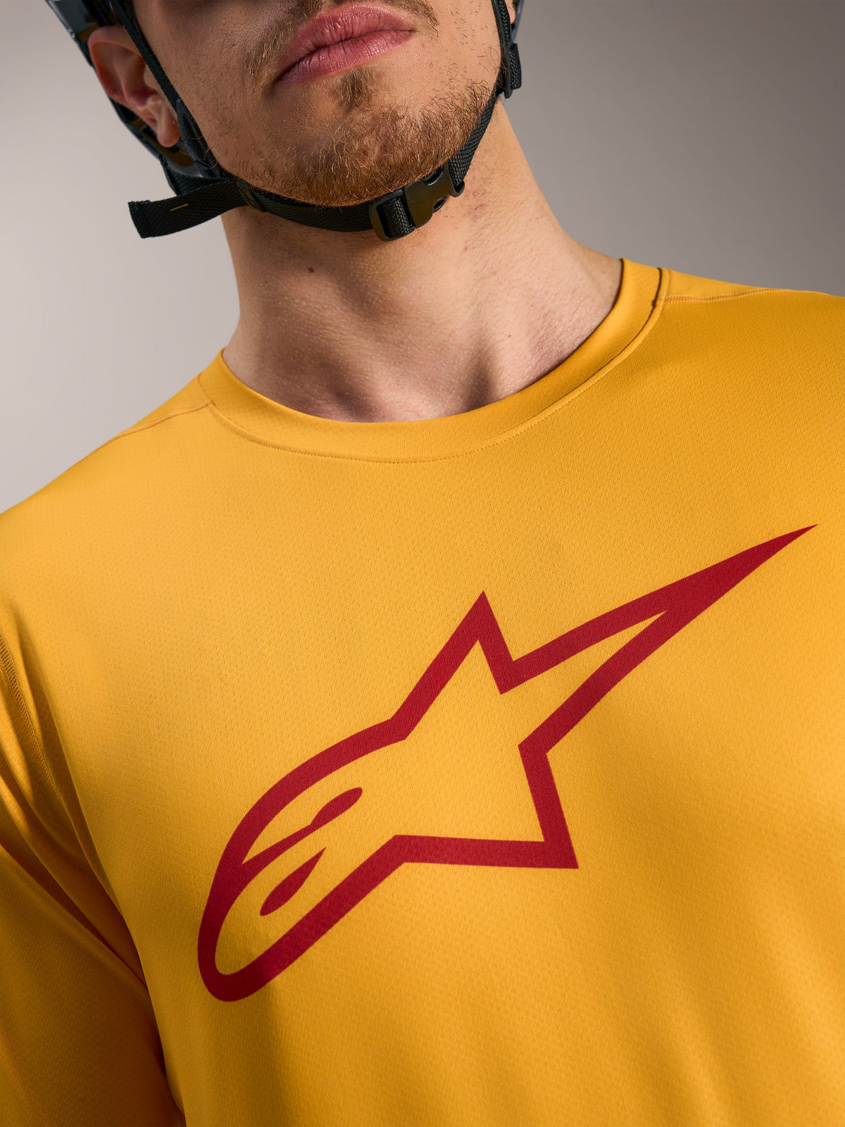 Maillot A-Dura Ride orange Alpinestars, logo Astars rouge sur la poitrine, vêtement technique léger pour le VTT.