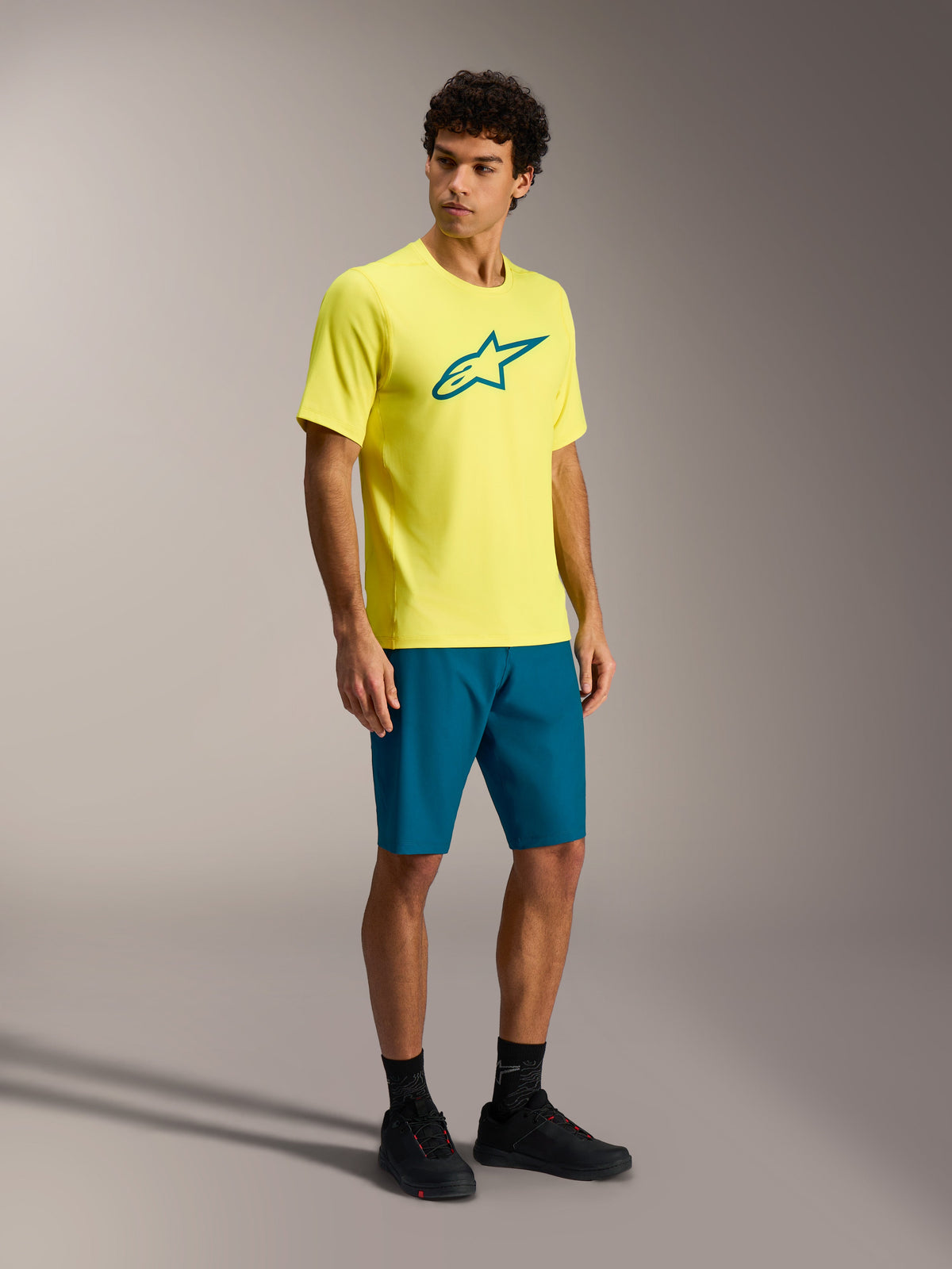 Tenue VTT Alpinestars A-Dura Ride, maillot jaune à manches courtes et short bleu-vert sur un mannequin homme