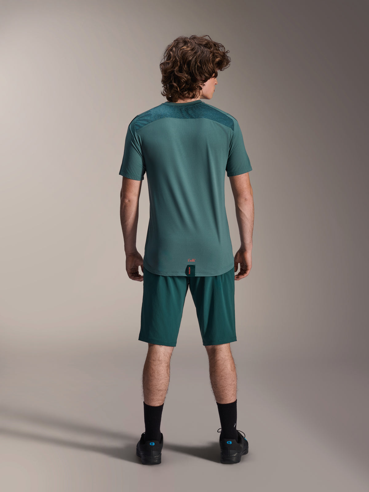Short Alpinestars A-Dura et maillot A-Dura Lipan SS, vert Dark Pine, vue de dos sur un mannequin, vêtements de VTT haute performance comprenant un maillot à manches courtes et un short assorti, tenue de cyclisme tout-terrain