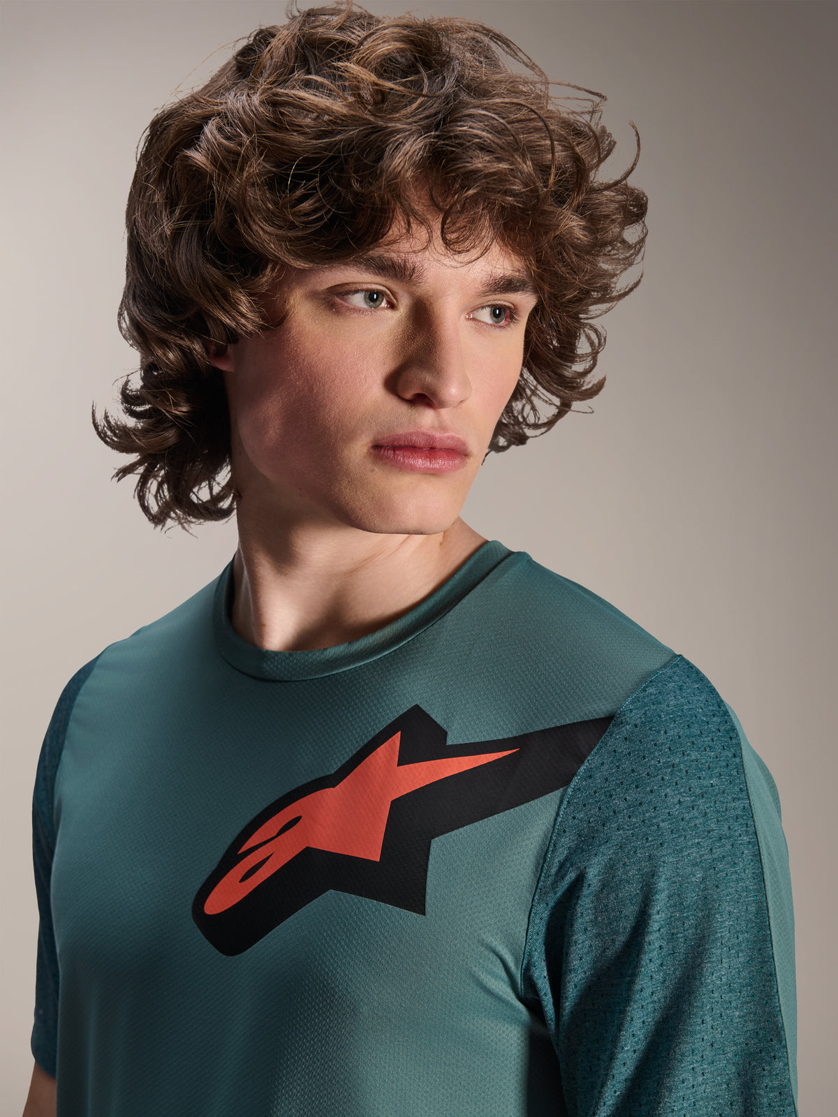 Alpinestars A-Dura Lipan Jersey, Short Sleeve MTB Jersey, Silver Pine, features a prominent red and black Astars logo on the chest, textured jacquard sleeves, close-up portrait of model wearing performance cycling gear