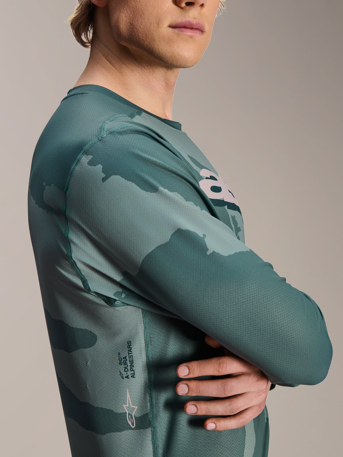 Maillot à manches longues Alpinestars A-Dura Hollow Camo, Silver Pine Camo, motif camouflage vert, avec le mot-symbole A-Dura et le logo Astars sur le côté, vêtement technique de VTT
